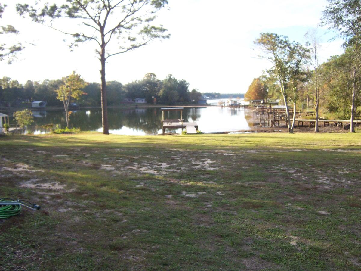 Beautiful developed 1.32 +/- acre with 2 septic tanks, Deep well, and 200 amp power pole and full RV hook up. CERTIFIED SURVEY OCT 21, 2019 to be 1.32 ac with approx 150 ft waterfront! Property has a large dock partly covered and pier leading onto dock on Juniper Lake approx 670 acre lake well known for good fishing!!). St. Augustine sod was installed part of the lot down to the waterfront. Water depth at the end of the dock is approximately 8 ft deep at full lake level. Property is one of the largest lots available and has access off Widner Cir and Black Bass Ave with large gates on both roads. Fenced Lot. 10x20 storage building. Also comes with a very nice RV already in hooked up. 2013 Open Range Light Model 297RLS with new leather Lazy Boy loveseat & new queen mattress. Sold ''As IS'' State has lowered lake for maintenance and is in the process of raising it back up.