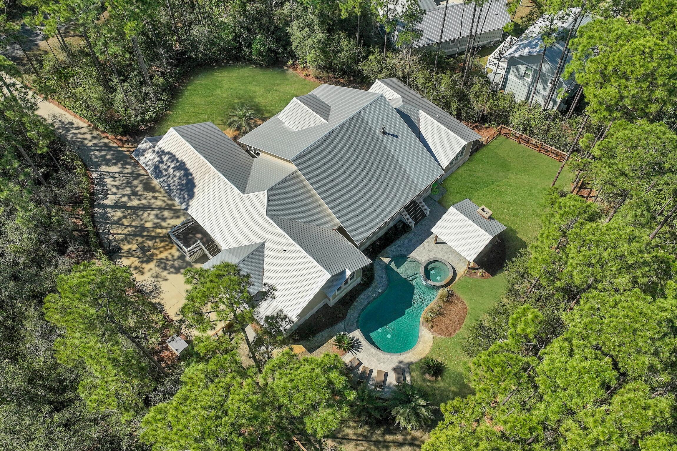 Nestled within the serene confines of THE WOODS, a tranquil bay-front community in Pt Washington, lies 164 North Brookwood Drive. This custom home, set upon a private wooded 0.6-acre estate, offers a seamless blend of modern comfort and natural beauty. Boasting over 3,900 square feet of single-story living space, its design emphasizes both luxury and practicality.

Step inside to discover a thoughtfully crafted interior, featuring a spacious owners' suite, a versatile split floor plan, and the cozy ambiance of a fireplace. The heart of the home is its expansive kitchen, adorned with double islands, catering to both culinary enthusiasts and gatherings alike.

Outside, a backyard paradise awaits, complete with a refreshing pool and spa, cabana and fireplace, all enveloped by lush professional landscaping. This tropical oasis provides the perfect setting for relaxation and entertainment, offering a retreat from the bustle of everyday life.

Residents of this idyllic abode enjoy the added amenities of THE WOODS community, including a neighborhood trail and a private dock on the bay, fostering a sense of connection with nature. Furthermore, its prime location ensures convenient access to nearby schools, shopping destinations, and the pristine white sand beaches of 30A, promising a lifestyle of ease and enjoyment.
