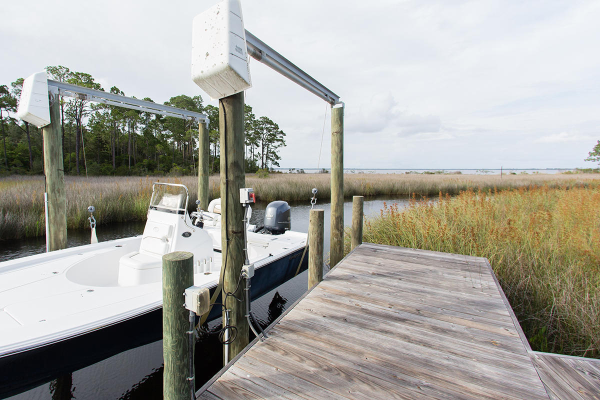 This waterfront, two-story plantation home is custom built and is situated on one acre of lush high and dry woodlands opening to the Choctawhatchee Bay. A boardwalk from the backyard leads to your own private dock and boat lift. The house is set off the main road by a long circular driveway. You will be welcomed by a wide relaxing front porch with a Bevelo gas lantern, front porch swing and mahogany double doors. The expansive rear screened porch makes a great place for entertaining with a large wood burning fireplace and gorgeous views of the bayou and bay. When heading indoors for the evening, your family will enjoy the spacious kitchen and den area along with 5 bedrooms (master on main) and 4 full baths. The entire house has a coastal, rustic feeling with heart of pine plank flooring, shaker cabinetry and reclaimed wood beams.

The Estuary is an upscale, bayfront gated neighborhood with beautiful oaks and estate sized lots. Just minutes to the beach and the 30-A area, the neighborhood is conveniently located to schools, shopping and recreational activities. Buyer to verify all measurements and important information.