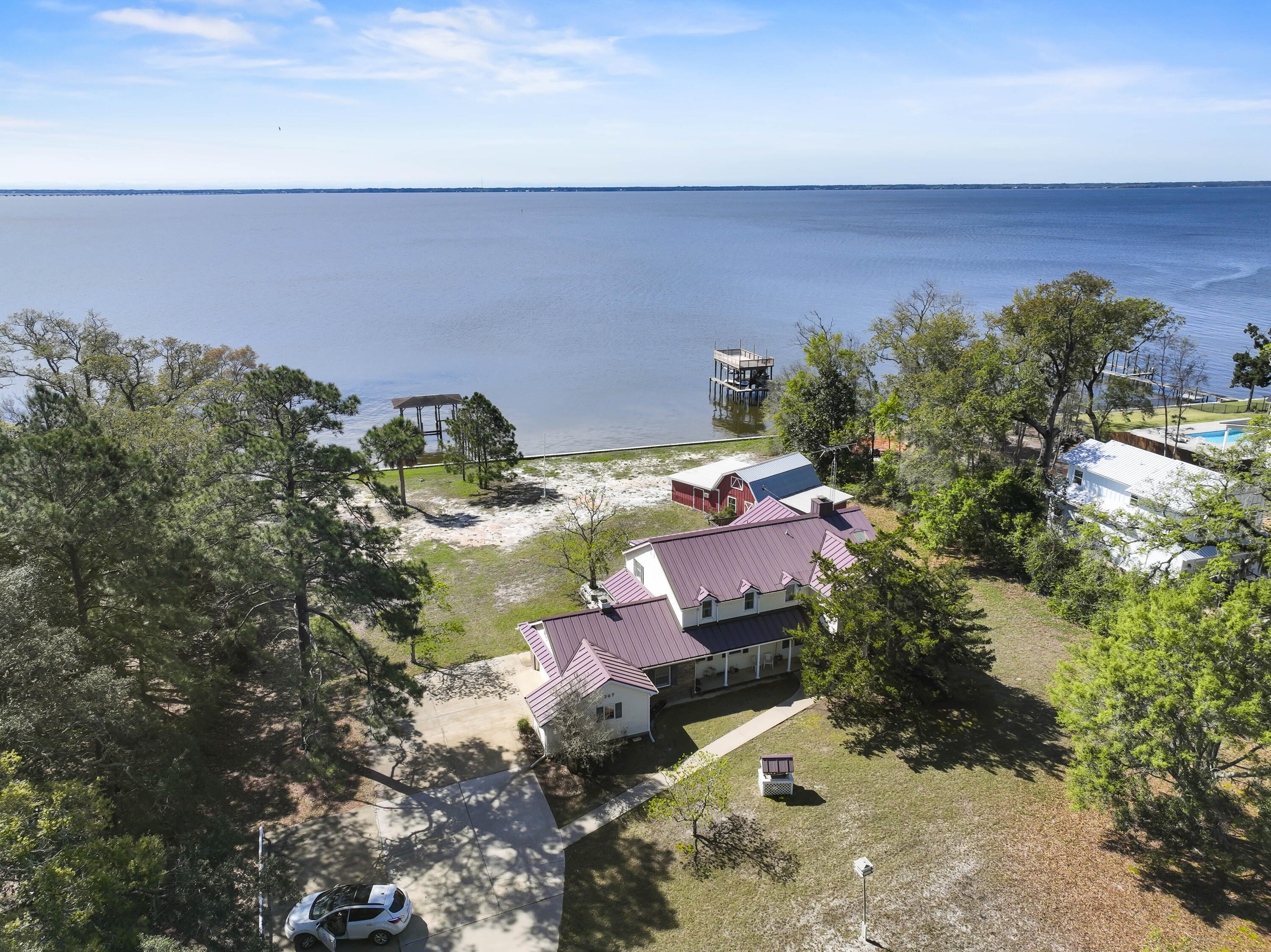 200 feet of waterfront! Elevated high above the Choctawhatchee Bay w/unbelievable views.  Gracefully surrounded by oaks, magnolias and newly built custom homes. This property is one of a kind and it is rare to find 200 feet of waterfront anywhere in our area.  Interesting fact - Red Barn Road is named after the large RED barn located on this property!  The home is in good condition but will need updating.  4 large bedrooms and 2 large living areas.  A screened in porch overlooking the water.  This home and homesite has so much potential.  Imagine yourself on the back porch at sunset watching the dolphins play...one has to view this scenic paradise to appreciate it.