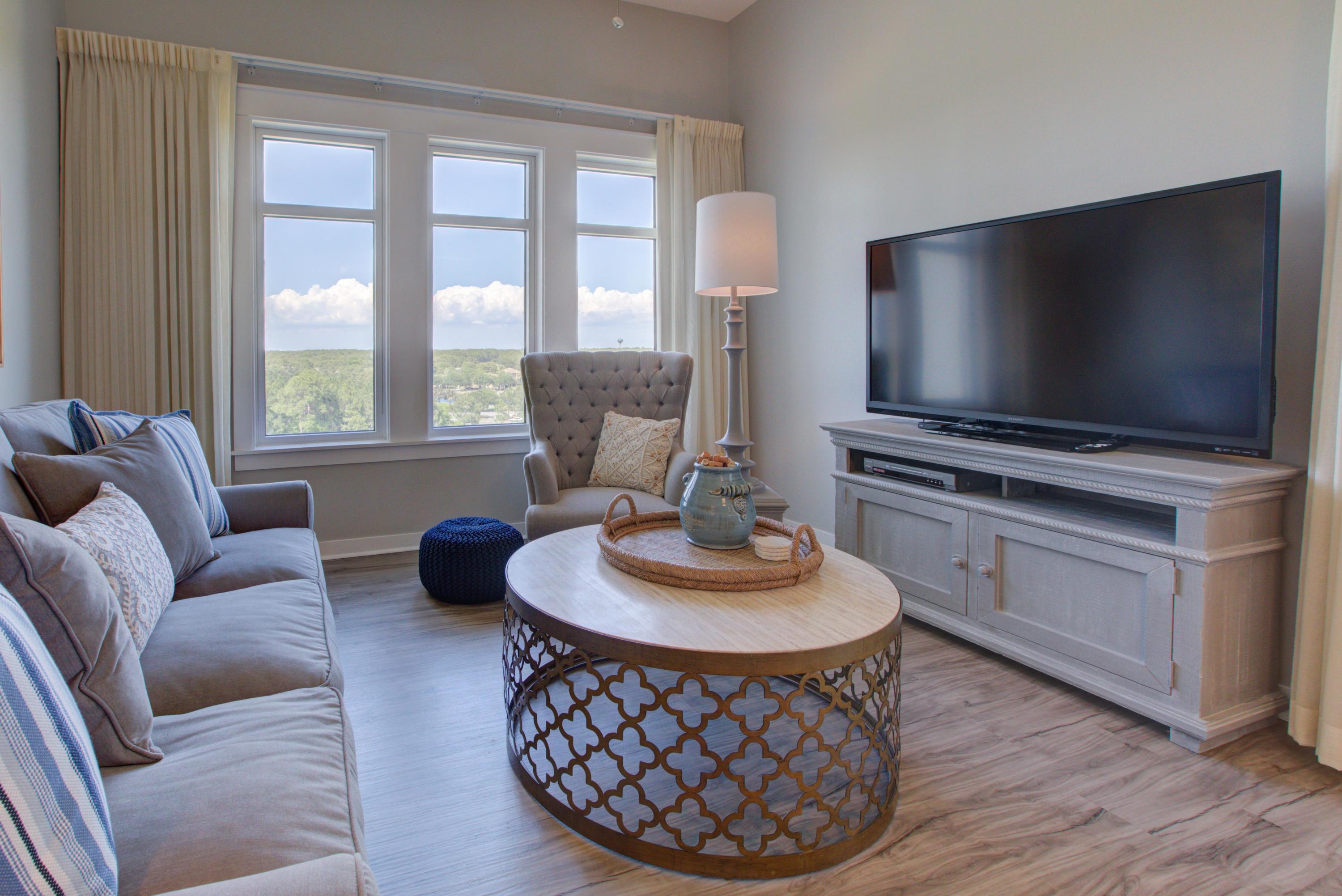 Sleeping Arrangements
One Story Unit / Master, King Bed; Living Area, Sleeper Sofa
Experience Your Vacation Haven
Extraordinary views looking out onto a golf course, which seem to stretch on endlessly, can be enjoyed from the balcony of Elation 5722. Enter the amazing unit of Elation 5722 and follow the beautiful hardwoods floors to a pristine, luxurious, and contemporary living area with large and comfortable furniture, focused around a big, flat screen television on a wooden entertainment center that matches the furniture. When not watching the television, views of the expansive landscape can be comfortably seen from the sofa. A coffee table and an end table complete the room, suitable for holding beverages to enjoy while watching the television or for gathering around and spending time together. A wooden table with matching wooden chairs is sitting in between the living room and the kitchen, to serve as a dining area with a dining table. The kitchen hosts white cabinets with white granite countertops and stainless steel appliances, ready for you to make any meal you desire. The granite countertops extend out far enough to have a breakfast bar, with three chairs, on the opposite side of the kitchen, in between the kitchen and the living room. The hardwood floors will lead you down the hall to the elegant master bedroom, where a king size bed awaits. There is a nightstand with lamps on either side of the bed, and a flat screen television perched up on a dresser for you to watch television from the comfort of your bed. Along with a beachy theme design, the room has a large sliding glass door that leads out onto a balcony, an amazing spot to have a beverage and watch the sun rise or set over the beautiful Destin landscape. The bathroom also has the same beachy theme that the bedroom has, along with white granite countertops like the kitchen, two sinks and a traditional yet lovely bathtub and shower combination. The balcony has a table and chairs, so you can relax while watching the sun come up or watching golfers tee up for their early morning round of golf. The unit also has a washer and a dryer, so you can easily get laundry done during your vacation, without needing to leave the comfort of Elation 5722.