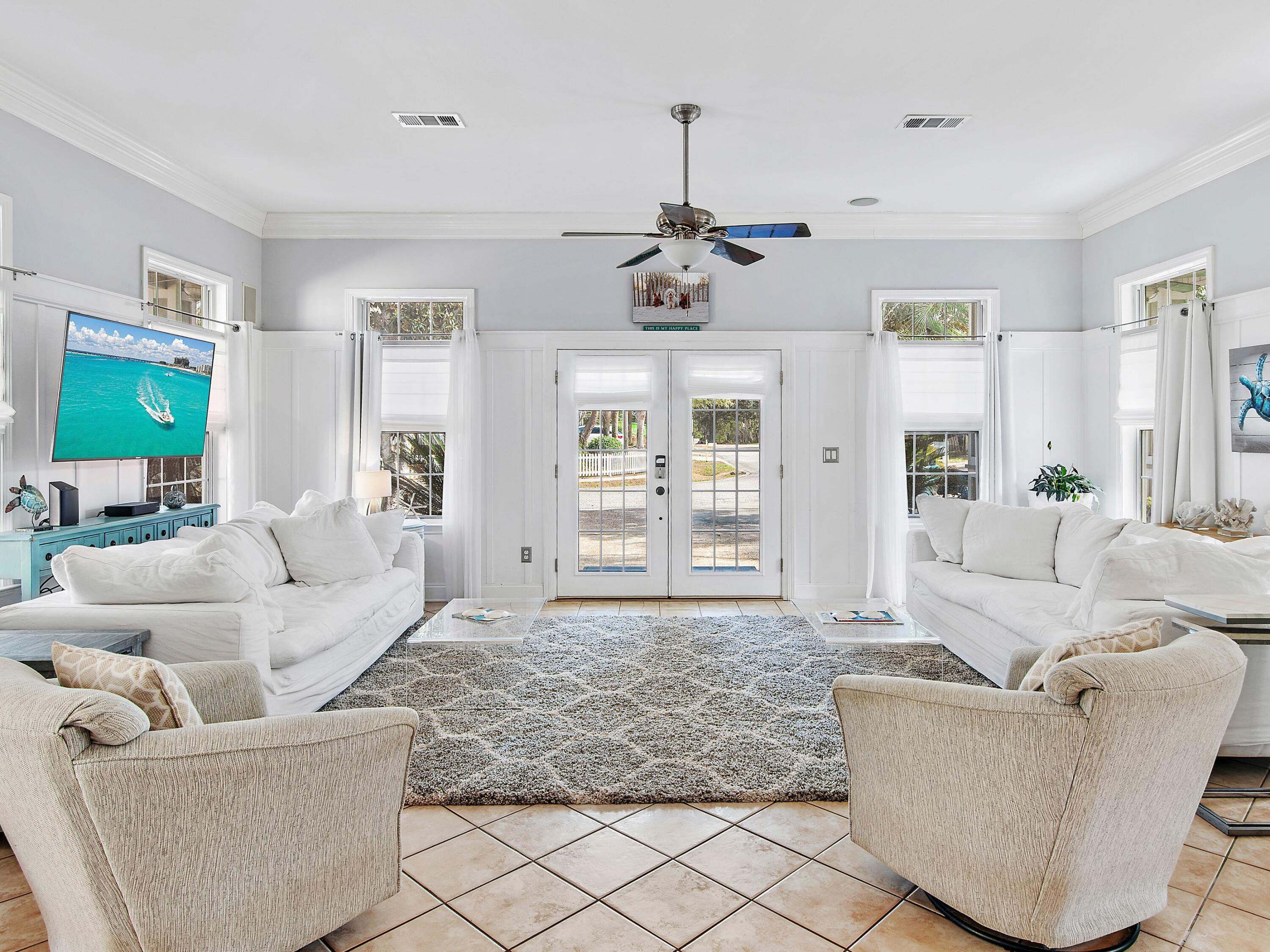 Nestled just two blocks from the pristine sands of Crystal Beach, Sovereign Isle emerges as a beacon of coastal living. This unique Florida cottage, a treasure within the sought-after enclave, offers an unparalleled blend of comfort and sophistication. With its one-story design, the home boasts 10-ft. ceilings adorned with crown molding, creating an airy and inviting atmosphere. The living spaces resonate with harmony, thanks to the integrated surround sound system extending to the master bedroom and outdoor areas, enhancing every moment. The heart of this home, a kitchen outfitted with granite countertops and stainless steel appliances, opens to a very large dining room, setting the stage for memorable gatherings. The spacious bedrooms promise restful slumber, while the master suite indulges with a luxurious bath, featuring double vanities, a whirlpool tub, and a separate shower. The allure extends outdoors with wraparound porches totaling nearly 400 square feet, offering serene views and a gas fireplace that adds warmth to both the dining area and living room. Updates to the home include a new roof in 2022, a new refrigerator (2019), HVAC replaced in 2015, new backsplash, new interior paint, new light fixtures and light switches, and parking accommodates two cars and two golf carts. Beyond the confines of this exquisite home, Sovereign Isle presents a community pool, adorned with koi ponds and fountains, set amidst lush grassy areas for recreation. This residence is not just a home but a lifestyle choice for those seeking a full-time residence, a vacation getaway, or an investment opportunity in Crystal Beach and Destin. With low HOA fees, two blocks to multiple beach access points, and exclusive neighborhood amenities, Sovereign Isle stands as a testament to elegant coastal living.