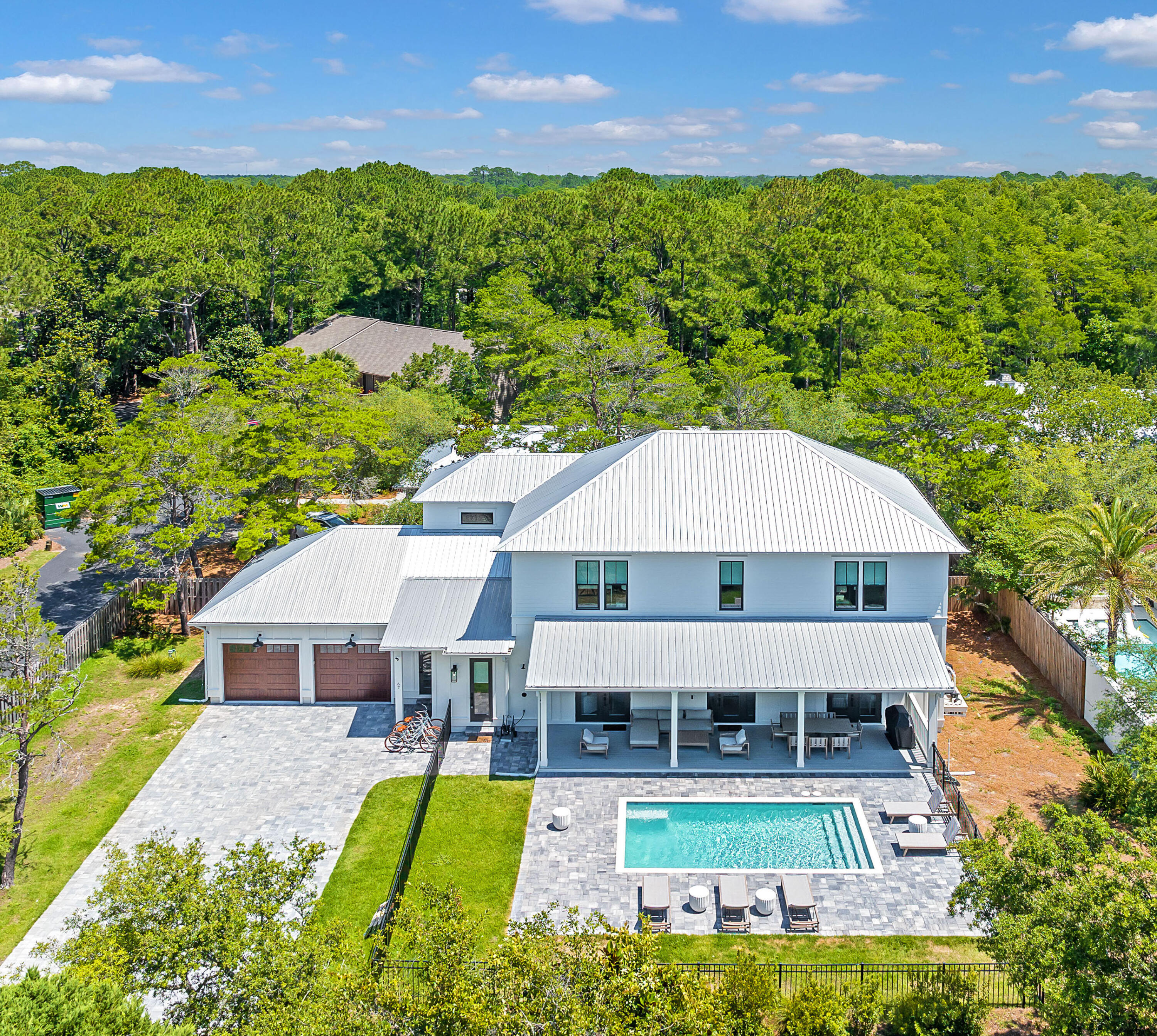 This exquisitely furnished home is nestled on a serene street just moments away from beach access in the highly desirable Seagrove Beach area. Positioned on an expansive homesite, this recently constructed residence features a captivating private heated pool and an attached two-car garage. Boasting 6 spacious bedrooms and 6.5 baths, it's thoughtfully designed to accommodate large families or multiple groups. Throughout the home, pristine white shiplap walls and gleaming hardwood flooring create a refreshing and contemporary experience with a distinct coastal charm. The main level hosts two inviting living spaces, with one providing a cozy setting for movie nights and relaxation. The larger living area seamlessly transitions into the dining space and kitchen, forming a stunning open-concept layout that's perfect for entertaining. The oversized chef's kitchen is a culinary haven, featuring a sizable island for casual dining and socializing. Custom Shaker-style cabinets, a six-burner stove, and quartz countertops are complemented by a striking gray-and-white herringbone tile backsplash, adding a touch of elegance. A full suite of top-of-the-line Bosch appliances stands ready to create culinary creations, while the walk-in pantry ensures efficient organization and small appliance storage. Outside, a fenced-in pool area and manicured lawn provide a secure and inviting space for children and pets to play. Three sets of French doors offer tranquil views of the enticing pool and landscaping, inviting seamless indoor-outdoor living. The expansive covered porch spans the length of the home and features a grilling area for alfresco dining and family gatherings. Multiple lounging areas offer opportunities for relaxation and poolside conversations. The main level hosts one master suite, while upstairs the primary bedroom boasts a luxurious separate walk-in shower and soaking tub. Three additional bedrooms on the second level provide direct access to baths, with a bunk room offering an ideal retreat for children. Each room is equipped with smart TVs, ensuring everyone can unwind with their favorite entertainment. Convenience is paramount with two laundry rooms, one on each floor, efficiently managing pool towels and beachwear. Furnishings curated by Design and Dwell blend comfort with style, elevating every corner of the home. Nestled within walking distance of pristine white sandy beaches, as well as 30A's renowned restaurants, shops, and entertainment options, this property offers the quintessential coastal lifestyle. Nearby Eastern Lake and Deer Lake State Park provide opportunities for hiking, kayaking, and paddleboarding, ensuring endless outdoor adventures await.