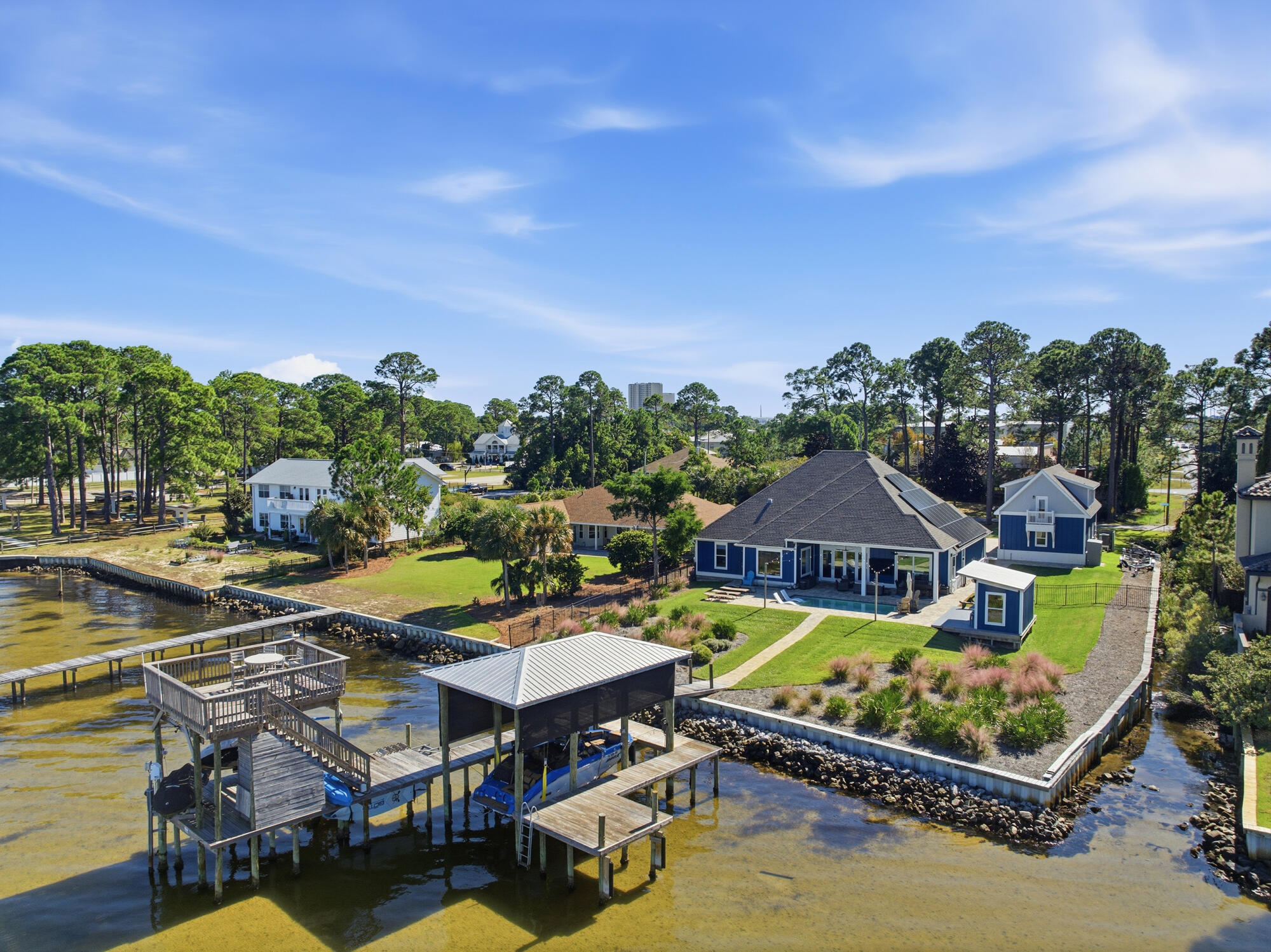 5 Bayshore Drive | Miramar Beach, Florida

Bayfront Luxury. Endless Horizons. Effortless Living No HOA

Along the tranquil expanse of Choctawhatchee Bay, 5 Bayshore Drive stands as a masterwork of modern coastal living -- a residence where architecture, light, and landscape exist in effortless harmony.
Each morning, the water glimmers just beyond your window. Each evening, the horizon melts into gold. Between those moments, life here unfolds in quiet rhythm -- refined yet relaxed, elegant yet entirely at ease. Inside, over 3,800 square feet of curated interiors celebrate both form and function. Sunlight dances across open living spaces designed for connection -- where walls of glass invite the bay to become part of the décor, and every room seems to exhale. At the heart of the home, a large kitchen anchors the home with a spirit of gathering. Mornings unfold at the breakfast bar as sunlight spills across stone countertops making it as inviting for casual mornings as for intimate evenings. Just imagine preparing breakfast in this gorgeous kitchen with plenty of storage, and a breakfast bar perfect for serving guests before heading to the beach. The adjacent living and dining spaces open to a covered patio and a custom saltwater pool that mirrors the colors of the dusk sky creating a seamless flow from indoors to open air perfect for entertaining or quiet reflection. Spaces flow with intention designed for conversation, celebration, and calm.

The main home's 4 large bedrooms, all include a private en suite offering serenity and style in equal measure. Throughout, every detail feels intentional: the textures, the tones, the light that changes with the day.

Beyond the doors, the landscape is a world of its own. Set on nearly half an acre with 100 feet of direct bay frontage, the property invites endless discovery. The private dock includes a covered boat slip and 6,000 lb boat lift, 2 jet ski lifts, an equipment cabinet, a swim deck and an elevated sunset deck - the perfect place to unwind as the sky transforms into a canvas of vibrant color each evening. 

Additionally, you'll find an inviting outdoor shower and fenced grounds thoughtfully designed for both privacy and play. The property also showcases an enclosed summer kitchen perfectly tailored to complement the home's architectural style. This charming multi-purpose outdoor pavilion offers the perfect blend of function and fun. Designed as a fully equipped grilling station, bar, and social lounge, it features a roll-up serving window with bar seating, a full-size refrigerator, built-in counter space, stainless sink, and mounted TVideal for game days, sunset cocktails, and weekend cookouts. The covered structure keeps the party going rain or shine, while the open deck creates a seamless flow to the surrounding lawn and waterfront views. Whether you're hosting friends or unwinding by the bay, this versatile space delivers the ultimate outdoor entertaining experience.

The homes 5 garage spaces are divided between an attached 2 car garage and an additional detached 3-car garage with a beautifully appointed 1 bedroom fully-furnished carriage house that extends hospitality or income potential. The eco-friendly solar panels bring modern sustainability to the fore.

Here, every day feels beautifully complete. Paddle at sunrise as dolphins play nearby. Spend lazy afternoons exploring Choctawhatchee Bay or the gulf's sugar-white sands. Then return home to sunsets that set the bay alight in shades of amber and rose.
Moments from Regatta Bay Golf & Yacht Club, Grand Boulevard, and the region's finest dining and boutiques, 5 Bayshore Drive is both a sanctuary and a statement - a place where the beauty of Miramar Beach meets the art of living well.

A place to gather.
A place to breathe.
A place to belong.

Welcome to 5 Bayshore Drive your sanctuary on the bay