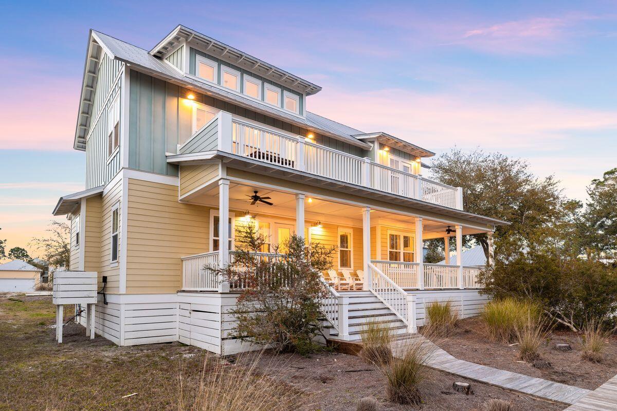 Experience coastal elegance and stunning bay views in this beautiful five-bedroom, three-bathroom home located in the desirable Windmark Beach community. This charming residence, featuring authentic hardwood floors and expansive open-air and screened porches, invites you to soak in the serene surroundings. The heart of the home is its modern kitchen, complete with a large granite breakfast bar, vaulted ceilings, stainless steel appliances and a spacious pantry. The open floor plan flows seamlessly into the great room, creating an ideal space for entertaining. Natural light floods through sizeable picture windows, highlighting the exquisite furnishings and welcoming ambiance. Step onto the large second-story deck from the kitchen to enjoy outdoor dining and breathtaking sunset views. The primary bedroom on this floor offers tranquil bay views and relaxing accommodations. Four additional bedrooms on the first floor provide ample space for family and guests, including two guest bedrooms with king beds, a bunk room with twin-over-twin bunk beds, and a guest bedroom with a twin bed and trundle, making it possible to sleep up to 12. Windmark Beach offers a wealth of family-friendly activities, including fishing, kayaking, biking and more. Just a few steps from the nearest beach access, guests will love the convenience of a quick walk or golf cart ride to the pristine sands and the community pool. The community also features bayfront amenities, docks, a bike/walking trail, fine dining, specialty shops and a fitness center. Currently on a rental program, this turn-key home comes fully furnished (with a few exclusions) and is ready for use as a vacation getaway or investment property. Embrace the coastal lifestyle in this exquisite home, where every detail has been thoughtfully designed to provide a relaxing and unforgettable experience.