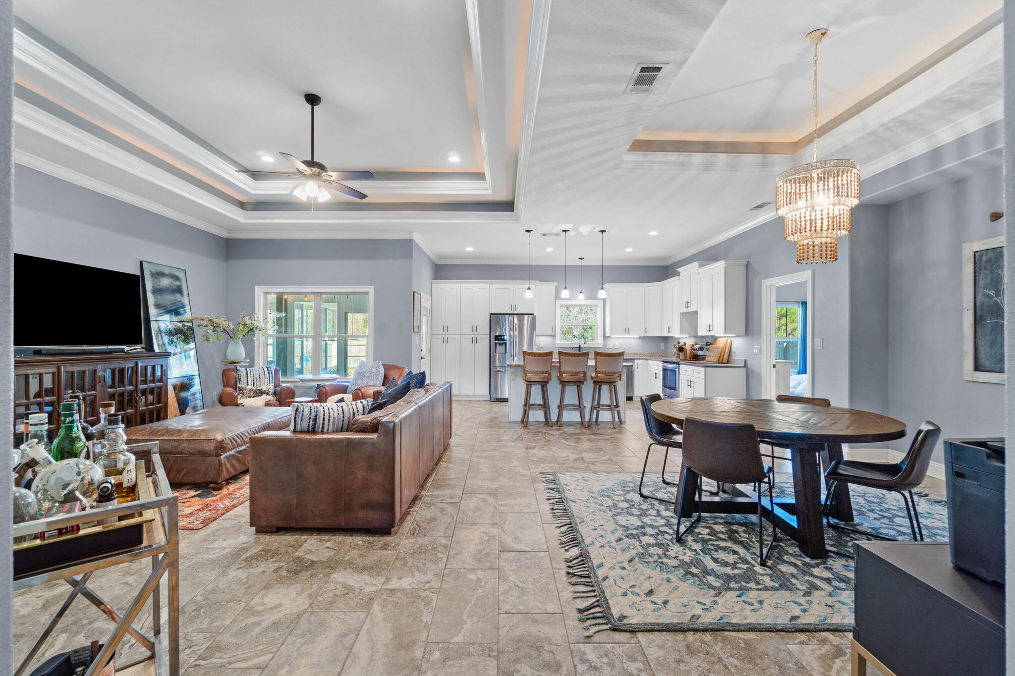 Absolutely stunning 4 bedroom east Navarre home on a unique and massively deep 1.19 acre lot (no HOA and built in 2018) and a gorgeous sunroom! Enjoy being walking distance to the YMCA and Navarre Youth Sports Association, minutes to Navarre's beautiful beaches, and a short commute to Hurlburt Field. Enter inside through a fantastic arched entryway and you'll immediately fall in love with the soaring 10 foot ceilings, crown molding, stunning trey ceilings, and open floor plan! With custom features throughout this beauty checks all the boxes. The well appointed kitchen is open to the dining and great room with abundant cabinets, stainless appliances, and granite countertops. The kitchen island is a huge functional space with plenty of room for seating and drop down pendant lighting.  The large living room has a double trey ceiling with recessed lighting where the ceiling goes from 10ft, to 11ft, and 12ft with 12x24 square floor tile! The split floor plan leads to an owner's suite suitable for a magazine cover with another double trey ceiling! The en suite bathroom is a jaw dropping oasis with double vanities, a separate soaking tub, and a walk in tiled showed with TWO shower heads and a glass door. There is a private water closet and a huge walk in closet with a door that leads straight into the nice sized laundry room! Talk about a functional floor plan! The other three nice sized bedrooms are located on the other side of the house with ample closet space and a shared bathroom between them. From the living room there is a beautiful addition of a 344sqft enclosed patio overlooking the spacious yard. Heated and cooled (though not included in the house square footage) this is an incredible space you will enjoy year round that will expand your living space and give you the flexibility you're looking for! Outside you'll find part of the property fenced in, but the property line extends FAR past the fence, in fact the lot is 627ft deep - full of possibilities to make your own! There is an irrigation system for the sodded and fenced in space, and the house is on a grinder pump connected to sewer (no septic, so plenty of room for a pool!). Don't miss out on this gem!