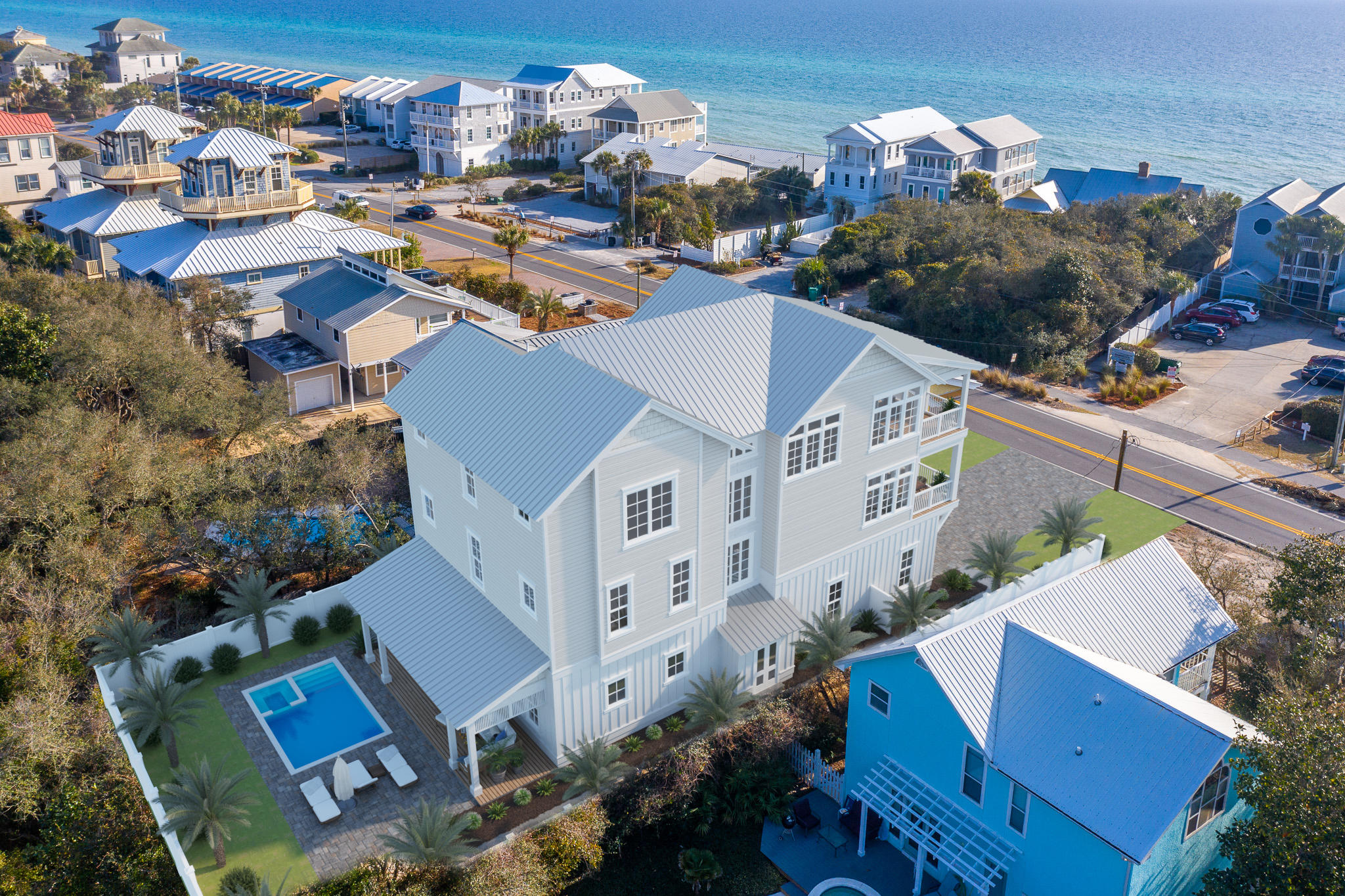 Construction is almost complete on this substantial retreat located just one tier off the Gulf in Seacrest. The home spans over 5,476 sqft (heated/cooled), and includes 8 bedrooms/8.5 baths, and 3 separate living spaces. The home also offers exquisite outdoor living spaces and unobstructed Gulf views, south facing decks on the 2nd and 3rd levels, a luxurious pool and courtyard, and an oversized 2 car garage.
Enter the property through the teak wood gates into the homes courtyard of peacock pavers and lush landscaping. The signature 10ft door welcomes in guests to the home's grand entryway and first floor living area. The first floor living room complete with wet bar with wine fridge, a double bunk room, 1 1/2 baths and this floor's laundry facilities finish out this space.