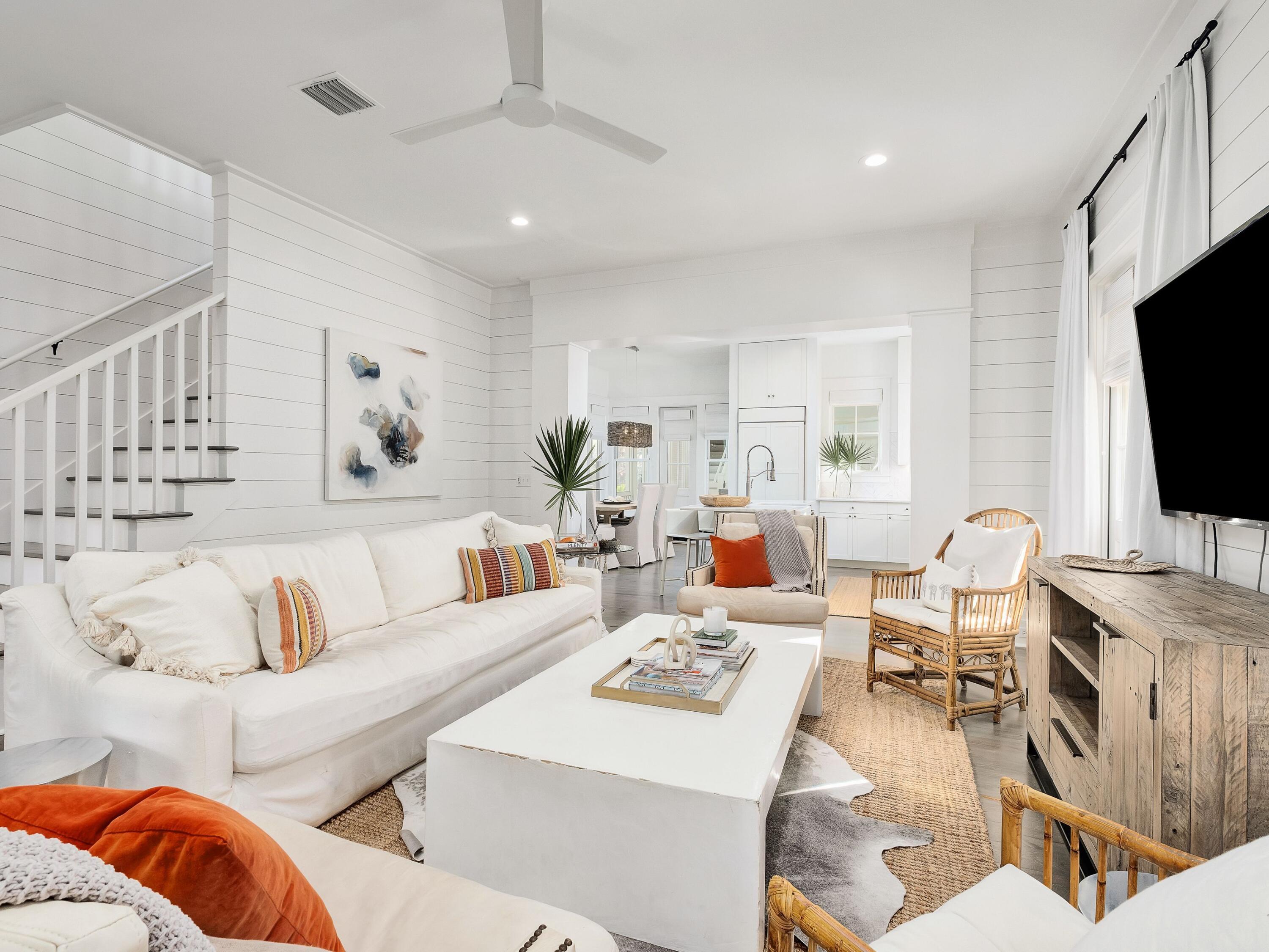 This newly remodeled WaterColor home with carriage house is enviably located in the community's Lake District, close to the serene Sandhill Pool and popular Camp WaterColor. The generous corner lot has ample space for five cars on the newly paved drive as well as a two-car garage and carriage house. Inside, the home is beautifully light and bright with an emphasis on all-white décor, new white furnishings, window treatments and shiplap walls. The sociable open living space is warmed by wood flooring and colorful accents. The kitchen has a built-in refrigerator, gas range and custom hood along with storage from floor to ceiling. The center island houses a farm-style sink and breakfast bar with three white stools lined up. This is the ideal home for entertaining family and friends with three bedrooms plus a built-in bunk room for four in the main house. The master suite is on the first floor and includes a master bath that has been completely updated. It features trendy shiplap walls and eye-catching barn doors hiding the closet. Shiplap was also added to the den along with all new lighting and refinished flooring throughout the property. There's an additional bedroom and bathroom in the guest quarters above the garage, connected to the main house by a covered walkway. The luxury lifestyle continues outdoors with a huge screened porch creating an enviable outdoor living space. Wood deck flooring and a comfortable corner sofa create an understated level of laid-back luxury. To the side and front of the house, there's a shady wraparound porch that's ideal for alfresco dining and reading. If you can tear yourself away, the home is a short stroll from the walking bridge leading to the Town Center. WaterColor amenities outshine the rest with a Beach Club, gulf-front dining, multiple pools, parks, boardwalks and even a lazy river in Camp WaterColor.