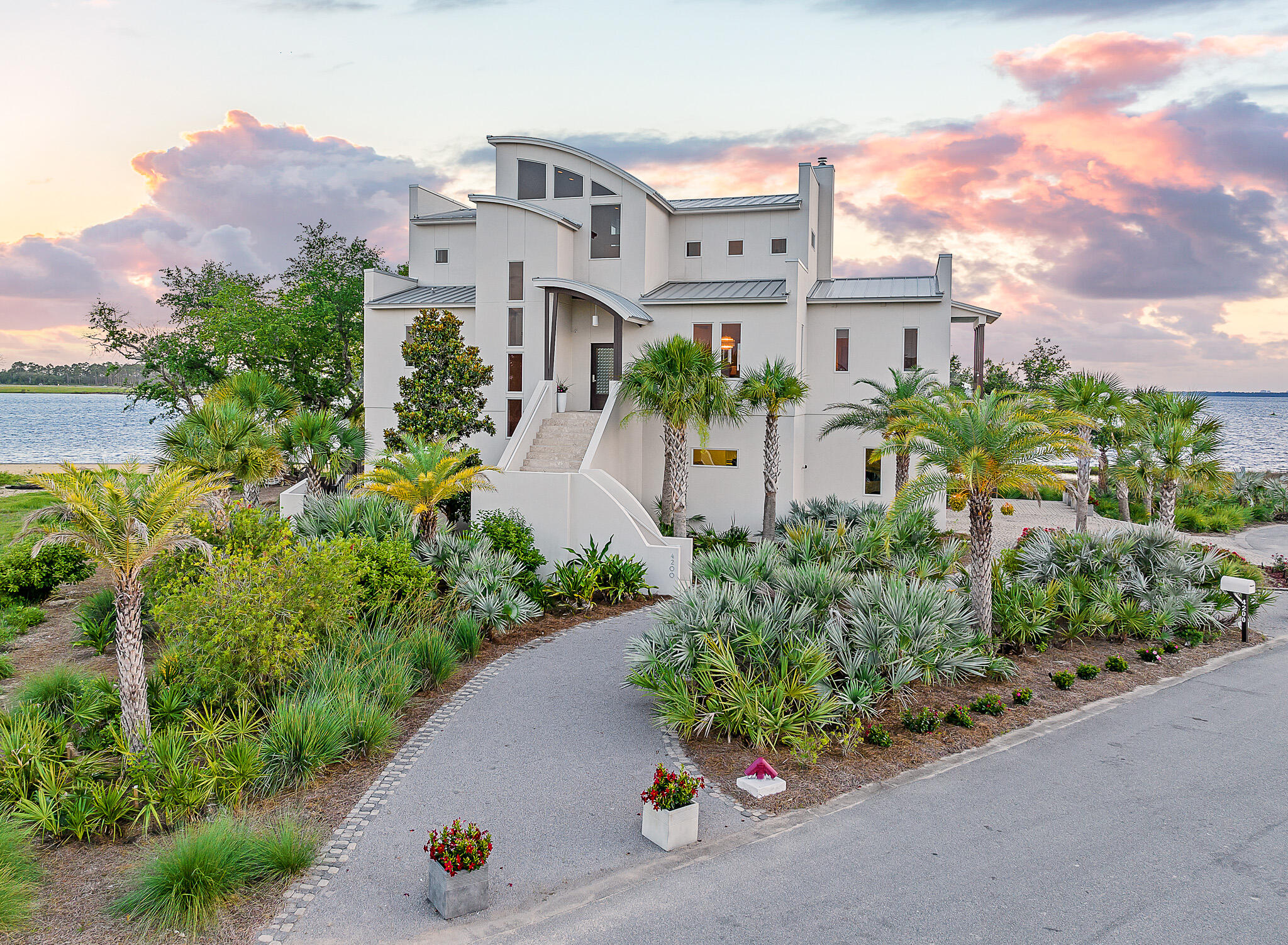 Nestled on the shores of North Bay, on a private island just off the coast in northwest Florida, sits a truly quiet and peaceful oasis of natural tropical beauty and a home of remarkable contemporary and modern architecture. This soaring three story estate was masterfully designed and brought to life by renowned Architect J Michael Hunnicutt and built by Rita Jones Construction. Spanning three levels with over 5,000 square feet, every room provides incredible waterfront views and offers expansive outdoor living with bay view covered porches on each level. With deep water and the Gulf of Mexico just 10 nautical miles away with NO idle speed zones in between, this luxury residence provides endless opportunities for fishing and boating enthusiasts with a private 350' dock.

 
Upon initial approach to the private island, you are welcomed by natural native landscaping and the soothing sounds of the Bay. This impressive 3 story home is framed by picturesque views of the Bay, surrounded by cascading sounds of the saltwater pool and spa which seem to blur the line between indoors and out.  The home includes a fully equipped outdoor summer kitchen and an 18' deep covered patio.  The summer kitchen is an entertainer's tropical dream. The custom kitchen cabinets are built of solid walnut sealed in marine grade varnish. The impressive cooking areas feature an all-Lynx luxury appliances package including a grill with rotisserie, dual cooking burners and power burner, and Lynx warming oven. Caesarstone quartz countertops and waterfall island are perfect for cocktails and entertaining. Situated on a large homesite and encompassing all that Florida's waterfront lifestyle has to offer, the deep-water dock will host your boat year-round and allows for residents to continue to pursue their waterfront dreams with boating, kayaking, and fishing! 

 
Step off the tumbled cobblestone paver driveway onto the travertine marble tile front entry steps to the stately front door and foyer framed with a custom Mahogany wood door with artistic blown glass. As you enter the main level, you'll be immediately drawn to the waterfront views at 23' elevation and a great room that offers tranquility and relaxation. A modern linear fireplace surrounded with marble and slate tile creates warmth in the space while framing full-glass French doors that lead out onto a covered patio overlooking both pool and Bay. From here you can take in gorgeous year-round sunsets as they sink into the horizon each evening. The second level anchored by the great room is completed with a stunning formal dining room, a remarkable powder room with Onyx walls and flooring with custom stone pedestal sink and a junior suite overlooking Bay and pool complete with full bath, walk in closet, and Juliet balcony. Polished travertine tile is found throughout the main floor and leads into the waterfront breakfast nook and Chef's kitchen.  

 
The fully-equipped kitchen boasts custom slab walnut cabinetry with soft-close hinges and pull-out drawers, 48'' Thermador Professional 6-burner gas range with double convection ovens and griddle, Electrolux convection microwave oven, warming drawer, Viking range hood and full-size Electrolux refrigerator and freezer. The kitchen features Caesarstone Quartz countertops and the oversized island that seats 4 is adorned with sleek waterfall edges as well as filtered cold and instant hot water at sink, pot filler at the range and a wet bar with wine refrigerator all designed with entertaining in mind! Adjacent to the kitchen is a 16'x10' walk-in pantry and laundry room with stunning granite countertops, custom cabinetry, elevated washer and dryer, built-in desk, shelving and sweeping views of the island.


Moving toward the Bay through the kitchen, you'll retreat into the primary suite. Overflowing with natural light and shimmering blue water from the Bay, the primary suite is luxurious and calming with custom walnut cabinetry with Swarovski crystal knobs, radiant heated Italian porcelain tile floors, an aquatic air tub gracefully accentuated with Bay views, an incredible, spa-like curved Grohe walk-in shower made from tumbled marble pebble rocks with 3 body jets and 2 hand showers and a large 14'x9' closet in the primary suite featuring fully enclosed cabinetry.  The primary suite also provides access to the spacious covered waterfront patio with fireplace and access to saltwater pool and spa below.  
 
Perched atop the third floor is the perfect place to admire the distinctive architecture of the soaring tongue and groove barreled ceilings and the famed Emerald Coast sunsets each night. This level offers a 19x16' loft living area with cork flooring and an office with French doors and private waterfront patio adding an elegant touch to this alluring space. Two large en suite guest bedrooms are located on the third level, each with walk in closets, walk-in shower, custom cabinetry, and radiant heated Italian porcelain tile floors, providing ample privacy and luxurious finishes. 
 
Sitting at 11' elevation, the first level of the home features a 35'x24' - 4 car tandem garage with doors that have a 150-mph wind rating. A separate 15'x10' workshop space in garage is ideal for the car enthusiast and boat lover. Step out of the oversized garage into the 
mud room and 26'x16' media-game room. This oversized entertaining area is off the pool and covered patio and features a full bath and fully equipped kitchen with built-in refrigerator, icemaker, dishwasher, microwave, granite countertops and walnut custom cabinetry. Imagine the memories that can be made here with days in the pool and nights watching movies and playing games. This floor also boasts a walk-in wine room with separate air conditioning system, double pane tempered glass door and custom shelving. The utility room is perfect for storage off the garage and media-game room and has a hidden "secret room" built for tornado and hurricane shelter. A unique feature of this home is the climate-controlled storage room. This heated/cooled room features hot and cold water, drain in the floor and a door to an enclosed outdoor area which could be perfect for the dog or animal enthusiast!  
 
The stately manor is built of cement filled concrete block walls, hurricane rated Anderson windows and doors, and frameless ½" tempered glass railing system around pool and porches for fully functional but unobstructed captivating views. A built-in generator fully powers the second and third floors of the home and there are high-efficiency heat pumps for each floor providing year-round comfort during the changing seasons. This rare offering combines luxury features with low maintenance like natural landscaping with a drip irrigation system on a programmable timer.  Another great feature for year-round comfort is a built-in automatic mosquito repellant misting system.  A modern outdoor LED lighting system and Deep Sentinel home security system are also notable features of this home. A new, standing seam aluminum roof was installed in 2019. Infrastructure on the island includes high speed internet, city water and sewer. Home has a personal buried 500-gallon underground propane tank. 
 
If you've been looking for an exclusive waterfront home with virtually 360-degree Bay views, then Northshore Islands is for you. This unique private island community represents an opportunity that is not to be missed. Inquire today to schedule a private viewing and start living the coastal life you desire. 

Visit www.4200northshoreislands.com for additional features, videos and information.