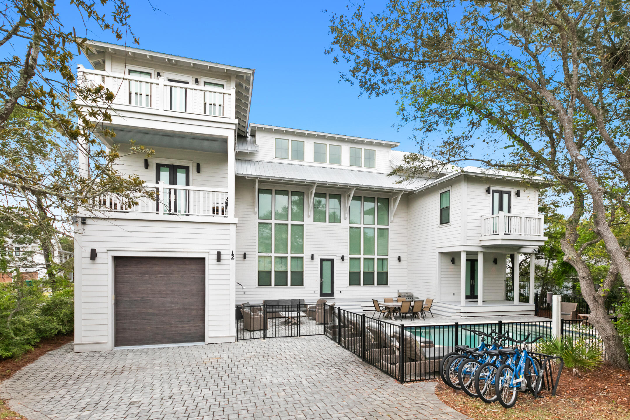 This stunning coastal retreat checks every box: Gulf views, sleeping arrangements for 16, a private heated pool, a garage, great rental income, and no HOA - all just steps from the beaches.

Inside, a dramatic three-story window wall floods the home with natural light, setting the stage for relaxed luxury across nearly 3,600 square feet. The open-concept main level is made for entertaining, with a chef's kitchen featuring high-end appliances, a spacious pantry, wine fridge, and a large island that flows seamlessly into the living and dining areas. A private first-floor suite opens directly to the pool, perfect for guests looking for a bit of privacy. You'll also find a convenient half bath, generous laundry space, and direct access to the garage for storing your gear after returning from the beach.

Upstairs, the smart U-shaped layout wraps natural light around every corner. The second primary suite has its own south-facing balcony overlooking the pool, while additional guest bedrooms and a cozy bunk nook provide plenty of room for family and friends. Two more full baths and a second laundry space keep things functional and effortless.

Head to the third floor for elevated Gulf views and a flexible living space. This level features a second entertaining area with a wet bar, full-size fridge, dining table, and lounge seating, plus another half bath and a spacious balcony perfect for catching sunsets.

Sold fully furnished and meticulously maintained, this one-of-a-kind property on 30A is ready for your next chapter  whether that's beach days with the family, investment income, or both.