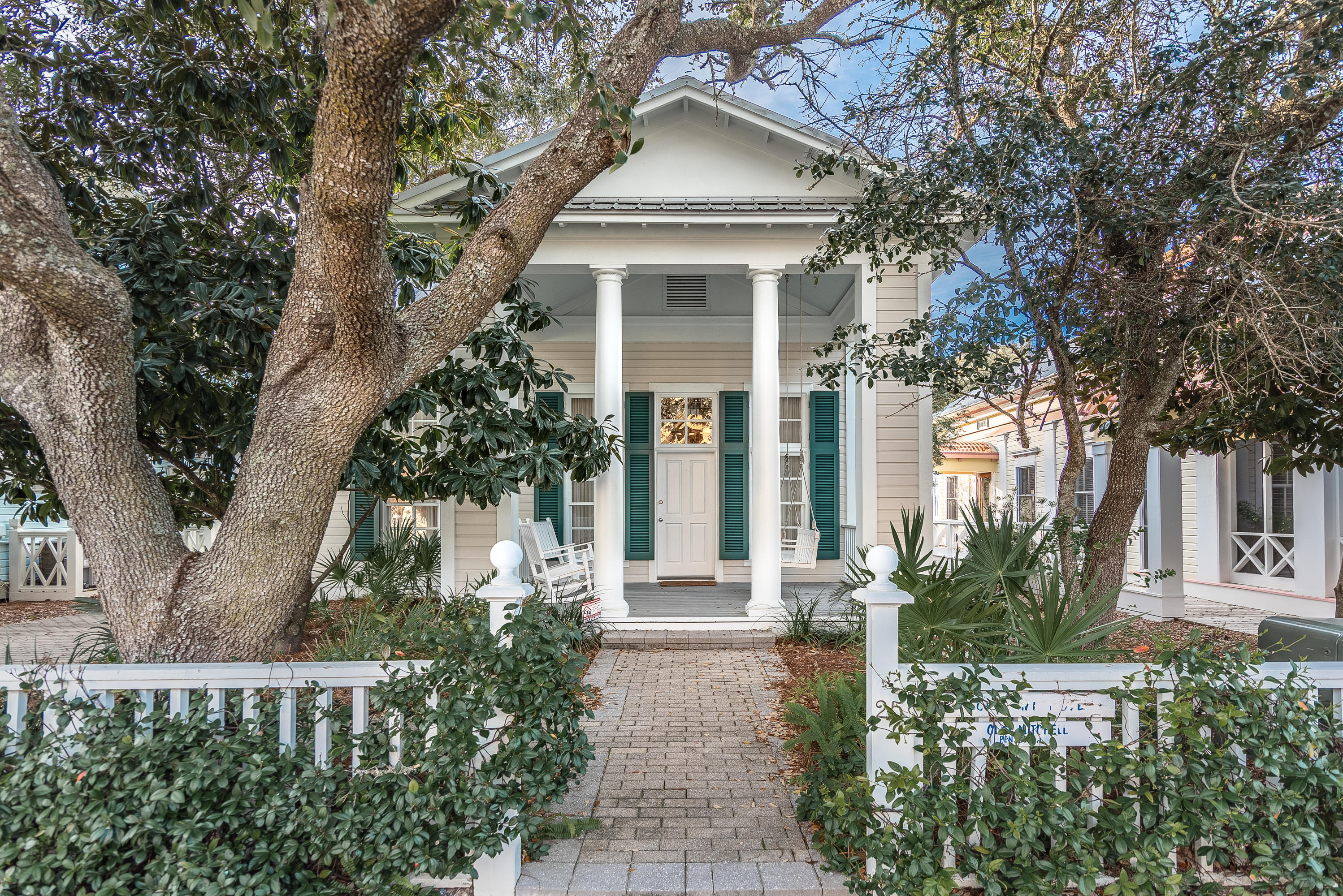 First time ever offered for sale, this lovely custom designed/built home is waiting to be discovered! Located two lots north of 30A, you're protected from road noise but just a few quick steps to the beach. Celebrate sunrises and sunsets from the unique Natchez 'umbrella' pavilion designed and built by the world famous Jersey Devils. While buffered by the Natchez Park to the west, this permanent green space assures you'll never have anyone build behind you!
Punctuated by Tuscan columns, this charming porch immediately invites you to relax and enjoy the sea breezes. Upon entering the home, you'll be struck by the soaring ceiling height and expansive living room. Beautiful heart of pine floors from North Carolina were given new life at the beach where they gleam
(continued).... as if brand new.  The well-proportioned kitchen is bright, white and so pretty, offering plenty of counter space, white glass-front cabinets, gas Viking  stove/range with griddle, Sub-Zero refrigerator and built-in microwave.  A breakfast bar seats four and overhead shelves can store your favorite cookbooks.  Even though spaces are well defined, the kitchen, living and dining rooms blend seamlessly creating the popular open floor plan.  A large wood burning fireplace cozies up the room on a chilly night.  Two bedrooms with en-suite baths along with laundry facilities complete the first floor.  An open staircase takes you first to a bright, spacious loft which can be used as an additional sleeping nook, then into the master suite with en-suite bathroom, walk-in closet and private deck â€“ the perfect place for that morning cup of coffee!  The third level tower bedroom and adjoining sun deck provide beautiful gulf and town views and also serves as the perfect perch from which to watch the July 4th fireworks!  The back yard sports a large open deck offering additional entertaining space.  Two outbuildings provide much needed storage â€“ the smaller one is two-part containing an outdoor shower and a home for the BBQ grills, while the larger can handle your bigger toys including a golf cart, or it can be converted to a guest house.  One of the longest driveways in Seaside provides plenty of parking for all your friends.