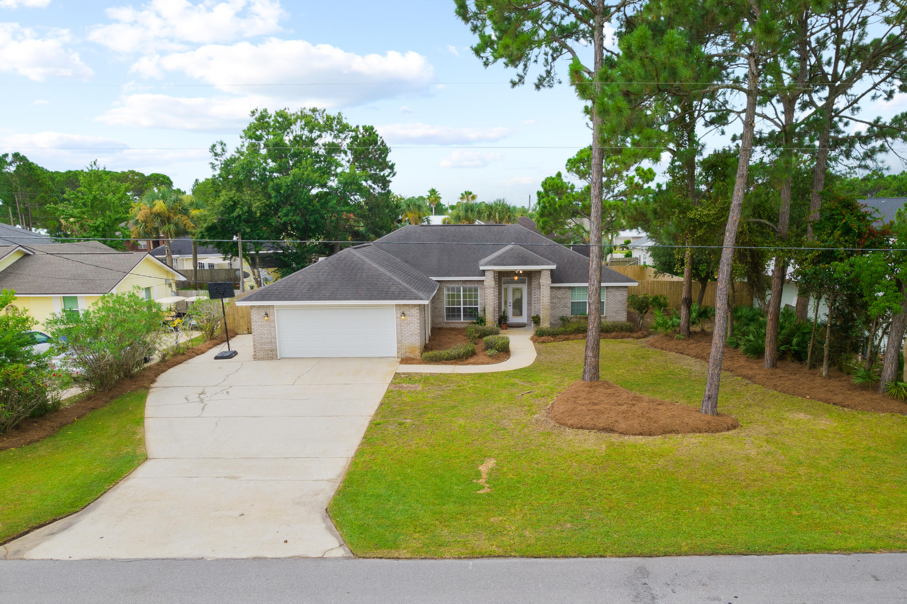7,500 CREDIT FOR RATE BUYDOWN AND CLOSING COSTS!  MOVE-IN READY WITH NEW ROOF, NEW FLOORS, NEWLY PAINTED INTERIOR!  Beautiful brick home in the highly desirable Holiday Shores Estates community of Miramar Beach. Situated on a large manicured lot in a quiet, serene setting, this home makes for perfect full time or second home living. Primely located just steps from the community bay access, and less than 1.5 miles to the Pompano Joe public beach access, this mediterranean influenced home offers modern living in the perfect location.  Custom built in 2001, this 1-story residence boasts a large split floor plan, with several notable features including 10' ceilings in the main living area, stainless steel appliances, and tile baths and showers. The interior of the home features freshly painted gray walls and white trim, and 6.5mm luxury vinyl plank flooring throughout the main areas and bedrooms. The kitchen also features an updated look with freshly painted white cabinets and beautiful countertops. With the roof just completed in October of this year, and the water heater replaced in 2020, there are no insurance obstacles for the new owner. In addition, the A/C was replaced less than 5 years ago.  The master suite offers a spacious bedroom and ensuite bath, and is highlighted by the tray ceiling with crown molding, large walk-in closet, and a tiled shower with separate garden tub.  The manicured backyard provides ample space for a pool and outdoor entertainment area, with a brand new white cedar playground set built and landscaped sand pit installed in 2021.  Complete with a spacious 2 car garage, this home offers an incredible opportunity to live, work, and play in the heart of Miramar Beach.  Families will enjoy the shopping and dining of the Destin Commons and Sandestin Outlets just 5 minutes away, as well as the public boat launch and basketball court at Legion Park.