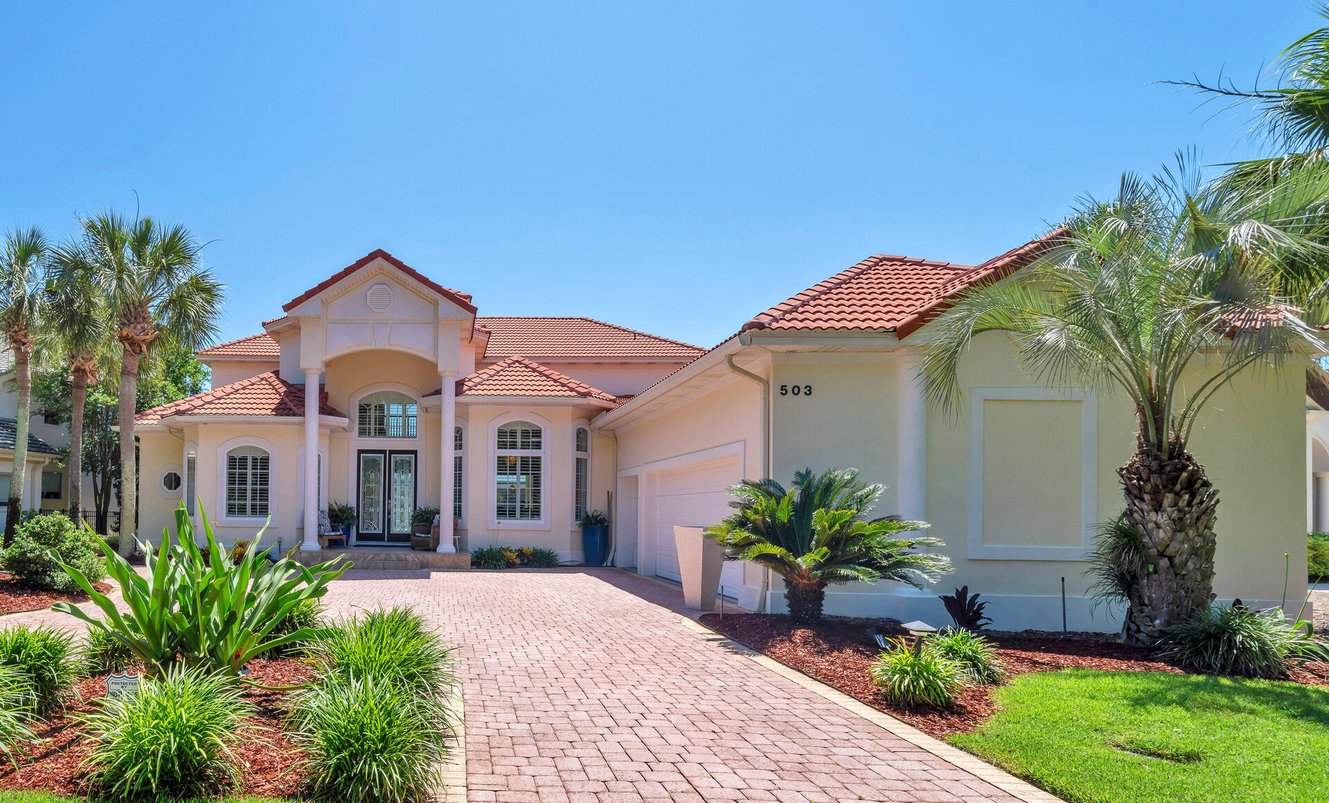 It's all about the VIEW! 503 Regatta Bay blvd is located lake front across from the 16th tee (no golf balls hit your home) in the prestigious Regatta Bay Lakes neighborhood.  This custom built home is excellent for entertaining with 20' ceilings, wide open spaces, a grand staircase, disappearing sliding glass doors that open on to the screened in pool lanai with non slip tile, hot tub, built in outdoor kitchen and plenty of room for seating that allows for al fresco dining while you watch the sunset nightly and fireworks 3 times a year bug free.  The pool bathroom helps keep water contained outside and comes with a shower to wash off the sand from the beach only 1.5 miles away.  There are door alarms for peace of mind with little ones too.  
The gourmet kitchen has custom dovetailed *Schrock cabinets, built in SubZero fridge, 6 burner Dacor gas range, built in Thermador oven and microwave, a Miele dishwasher, and a wine/drink fridge. New emerald pearl quartzite countertops, a deep Blanco granite sink with a hot water dispenser and a water filter system along with a custom center island with a wood Boos block top complete the space.

This multigenerational home offers 2 large primary suites on the main level on opposite sides for privacy. The main master wing has 2 large walk-in closets with built in organizers and the other is ADA equipped and also has a large walk-in closet. Both suites have sliding glass doors that open on to the screened in lanai and oversized bathrooms with *Schrock custom cabinets and tons of storage. The large bright laundry room off the main primary wing has a huge picture window that adds lots of natural light, has more storage and is also accessible from the hallway off the 2 ½ car garage.

A dedicated office off of the sitting room has lots of storage with 2 custom built in desks and custom cabinets and shelving.

There are 2 additional bedrooms upstairs with new light white oak hardwood floors. Bedroom #3 has an attached fully remodeled bathroom and the versatile bedroom #4 has a kitchenette with new quartz countertops, seating and storage, a small sink, 2 mini fridges, and a small dishwasher. A spacious bedroom, guest suite, or media room as owners currently use the space, great for watching the game with friends and family. The bunkroom can be a massive walk-in closet or an ensuite bathroom depending on the next family's needs.

The upstairs spacious screened in covered lanai has amazing views of the golf course, lakes, and skyline and is perfect for reading a book or relaxing.

Too many updates to list (full list is attached to MLS) to include 2 new HVAC units, new hot water heater, new pool pump, new quartz in laundry room, new granite installed in outdoor kitchen with custom tile backsplash wall for easy clean up, interior recently painted, new ceiling fans, 8 new screen panels replaced after SNOW!

Tile floors downstairs are easy to keep clean (sand) and newer carpet is on stairs and landing only.

Owners also have a 4 point inspection report and wind mitigation report dated 10/2024 for low home insurance available. There is a Generac whole home generator, 2 termite bonds grandfathered in to the property and a charger for an electric car out front on the side of the home.

Regatta Bay is a private gated community within walking distance to shopping, dining, Whole Foods, Destin Middle School, Lulu's, Legendary Marina and the beautiful Destin beaches. A perfect oasis, rated a top GOLF course by Golf Digest magazine, rated the safest community in Destin. Come experience the Regatta Bay lifestyle and make 503 Regatta Bay your home today. Video is available on Youtube, look up by address.