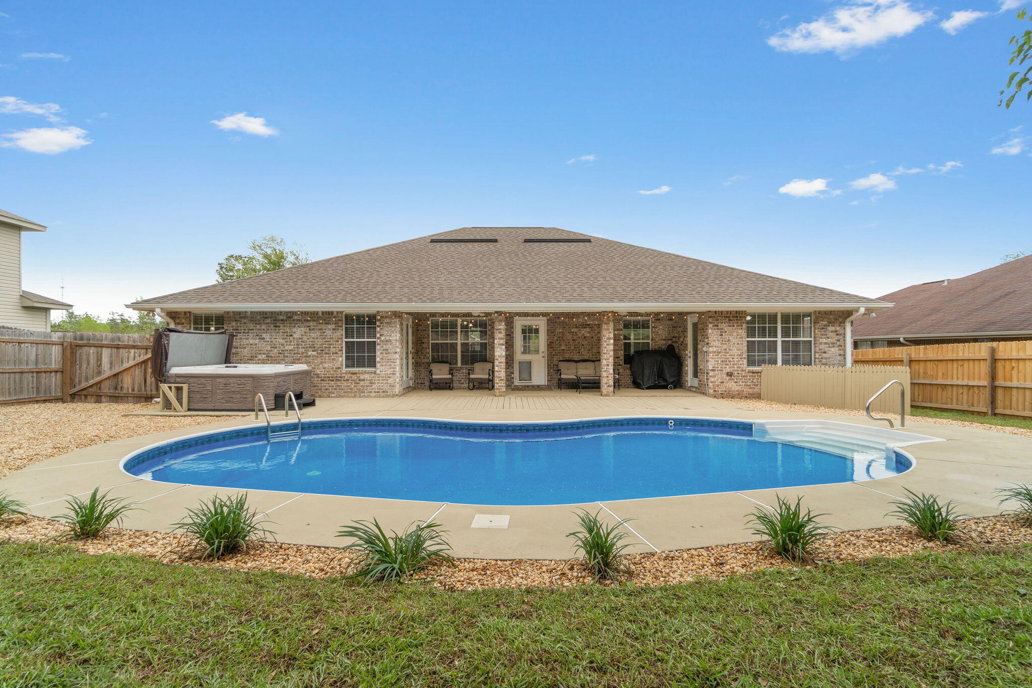 Welcome to this stunning all brick 4 bedroom, 2 bath POOL home with a separate dining room AND an office! Located on a cul-de-sac in the Iron Gate community of south Crestview (no HOA!), you will love this convenient location with an easy commute to local bases, a well updated interior, and a dream backyard (complete with a hot tub that conveys!) where you will enjoy the best of Florida living. Pull up in the driveway and appreciate the lovely landscaping and curb appeal, as well as the covered front patio. Inside you'll find an office to your left and a formal dining room to your right in over 2100sqft of a split floor plan. The spacious living room is wired for surround sound, and it leads to the eat in kitchen overlooking the well appointed and updated kitchen. Featuring high end granit countertops with rounded edges, stainless appliances, refinished cabinets, tasteful backsplash, updated hardware, and an updated sink and faucet you'll love cooking and congregating in this space complete with a pantry. The primary bedroom is a great space with plenty of room for your king bedroom suite and features a trey ceiling and french doors that lead to the covered patio. The primary bathroom has double vanities, a walk in slower, separate soaking tub, and TWO separate walk in closets. This thoughtful floor plan allows for one of the additional bedrooms to be by itself for additional privacy towards the rear of the home, and the other nice sized bedrooms with ample closet space are down the same hallway with a shared full bathroom. Visualize yourself enjoying your own backyard oasis features an in ground pool (with a brand new liner!), covered patio, hot tub, playground, firepit (the swinging bench can face the pool or be turned to face the fire pit!), and a fantastic outdoor storage shed. Have peace of mind with a July 2020 roof, 2017 HVAC (with an air purifier), and 2013 water heater. The pool was installed in 2014 and the liner was just replaced. Don't delay in seeing this rare and meticulously maintained gem!