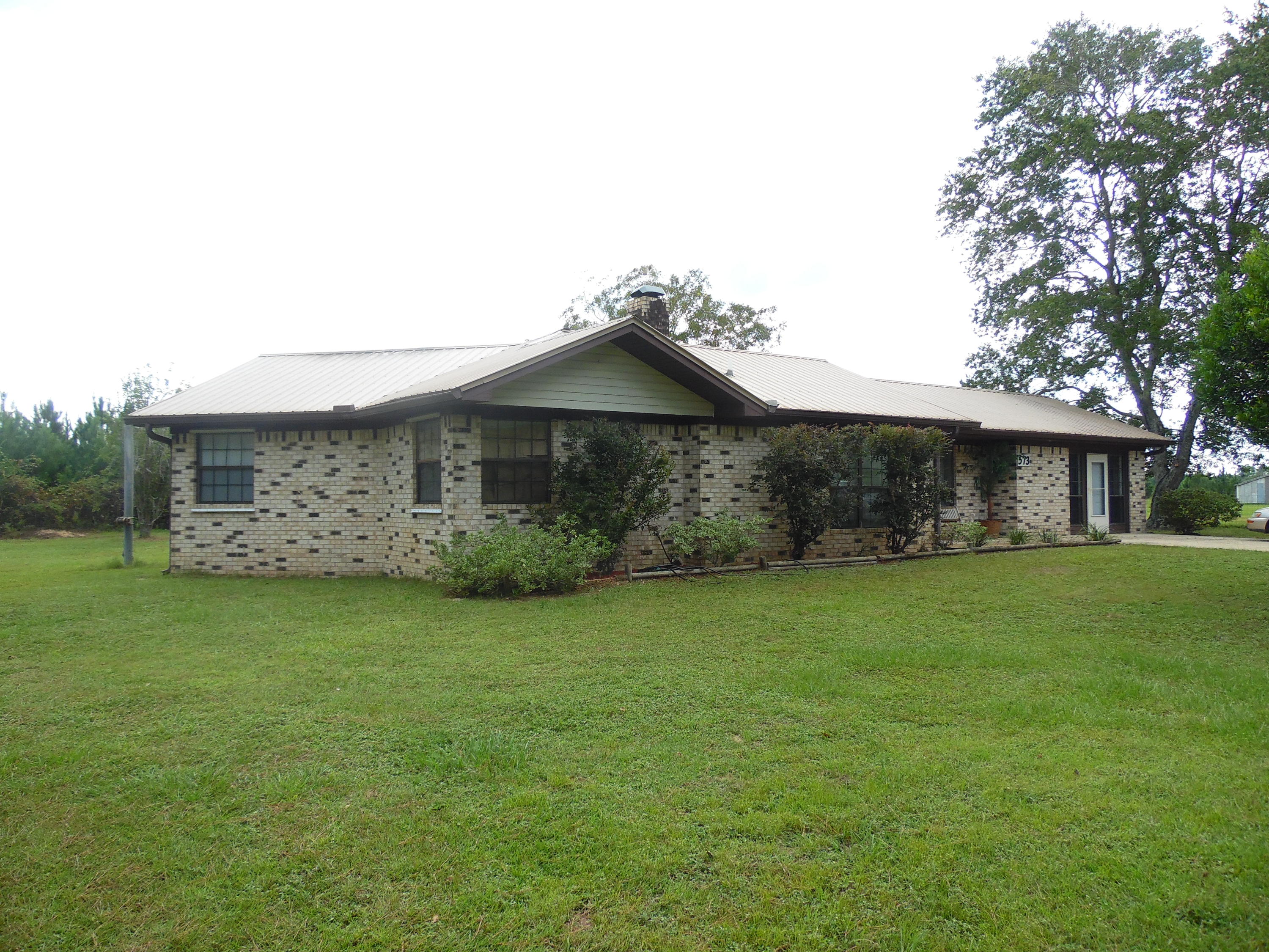 Priced to sell! Over 1900+ sq.ft. brick home with metal roof, near to town with 4 bedrooms, and 3 bathrooms on 1 acre. Has a 2 car detached garage and 2 utility sheds, one with a 2 car carport and roll-up door on shed, other shed makes a great hobby shop/workshop or a great ''man cave''. Home is completed with a FL room across the back of home 9x19';living room with wood burning fireplace joins large kitchen with dining area, perfect for a large family. Two large pear trees in the back yard that supply buckets of juicy pears each year. Perfect for those who like to make their own jam. Probably the Best Buy on the Market!