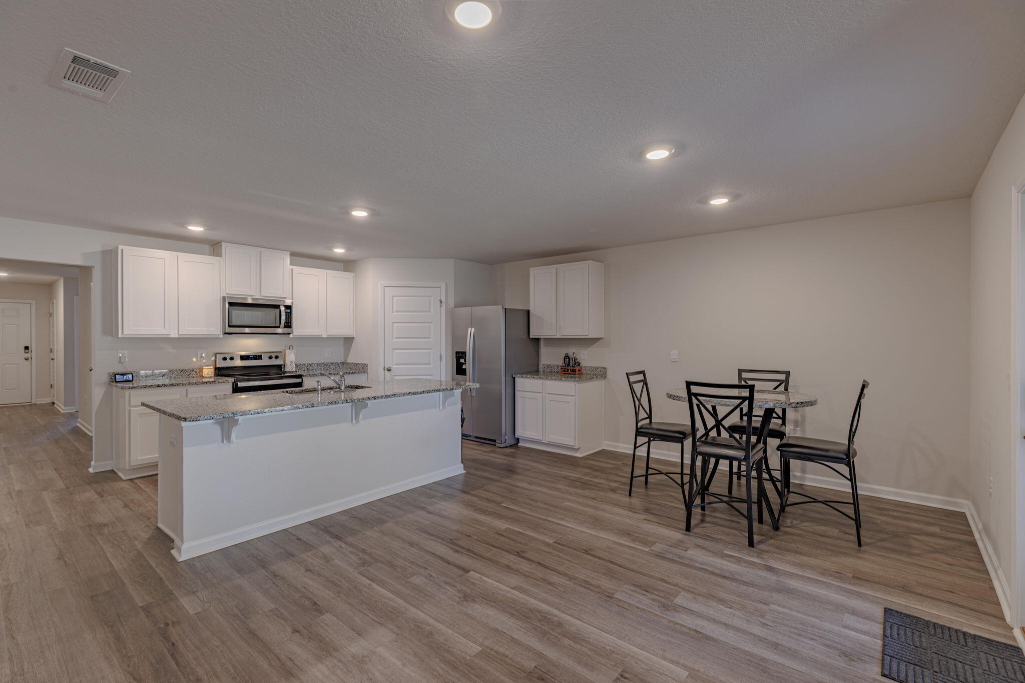 Hot New Price - motivated seller! This stunning 4-bed, 2-bath home features the popular Cali floor plan with 1,830 sq. ft. of well-designed space, backs up to wooded lot for maximum privacy. FHA assumption with rate of 5.99% with a small price gap available to qualified buyer. The open kitchen boasts granite counters, stainless steel appliances, a large island, walk-in pantry, and smart home system. The primary suite offers a walk-in closet, dual granite vanity, large shower, and linen closet. LVP flooring throughout, carpet in bedrooms. Enjoy a covered patio and massive fenced backyard, perfect for a pool, shed, or play area. Solar panels installed to help lower utility costs! Move-in ready—schedule your showing today!