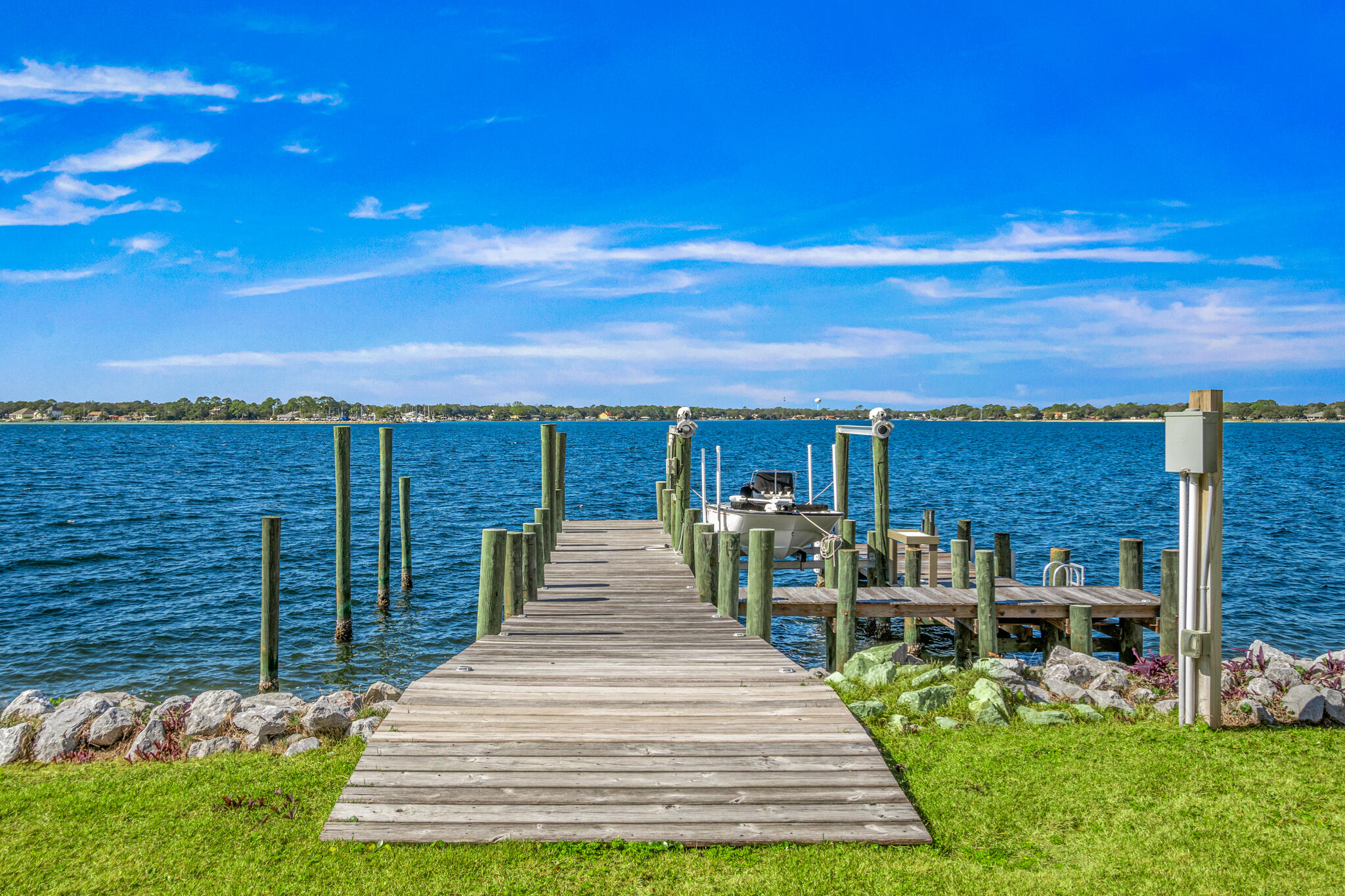 Welcome to The Pointe — the crown jewel and final available bayfront home in this exclusive 9-lot coastal enclave. Perfectly positioned on a rare point, this custom-designed masterpiece offers uninterrupted panoramic views of the bay, where daily dolphin parades, sailing regattas, and passing fishing boats unfold right before your eyes. From your porch, you'll take in unreal sunsets and soak up cool summer sea breezes in one of the most temperate and peaceful settings on the Gulf Coast.

Crafted for effortless indoor-outdoor living, this 4-bedroom, 3.5-bath home features four spacious porches, a cabana room, and a grand open-concept living area with soaring 10' ceilings that frame the water like art.

Built to the highest standards with impact-rated glass, soundproof floors, open-cell foam insulation, and an elevator reaching all 3 floors!

Whether you're a boater, angler, or simply someone who craves a front-row seat to nature's daily show, this home is the ultimate expression of bayfront luxury living.