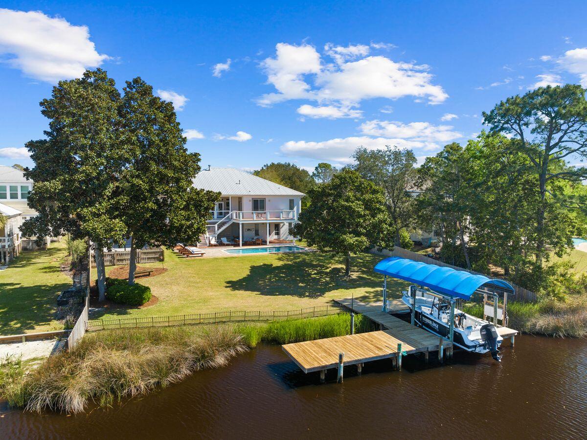 Perfectly situated on a spacious half-acre lot along a deepwater canal, this stunning home offers direct access to the bay and Gulf of America - a rare find in a peaceful, non-HOA community. Whether you're an avid boater, fisher, or sun-seeker, this is Florida waterfront living at its best. The property boasts a new pool and deck added in 2020, along with a new dock and boat lift that cater to an outdoor lifestyle centered around the water.

The home's elegant Southern-style architecture is highlighted by a grand double staircase leading to a spacious second-floor balcony. Elevated for enhanced views and peace of mind, the main living area on the second floor showcases breathtaking vistas of the canal and pool. Inside, a striking two-way gas fireplace serves as a focal point between the living and dining areas, enhanced by 10-foot ceilings and beautiful hardwood flooring throughout.

The updated chef's kitchen is designed with entertaining in mind and features an L-shaped island with ample storage, granite countertops, new backsplash, and new stainless steel appliances. The home includes four well-appointed bedrooms, including a serene master suite with a deep soaking tub for ultimate relaxation.

The first floor offers flexible living arrangements with a private guest suite or potential rental unit complete with its own modern kitchenette, living area, bedroom, bathroom, and an additional bonus room that can be used as an office or flex space.  This spacious area is ideal for extended family, guests, or long-term tenants.

Recent updates include completely remodeled master and guest bathrooms, a new rear deck, new flooring on the front porch and in the laundry room, and a tankless water heater. A sweeping circular driveway provides ample parking, and the spacious front and back yards add to the home's charm and functionality.

Perfectly blending comfort, style, and location, this property is just minutes from shopping, dining, and entertainment. It truly offers the best of waterfront living in one of the area's most desirable communities.