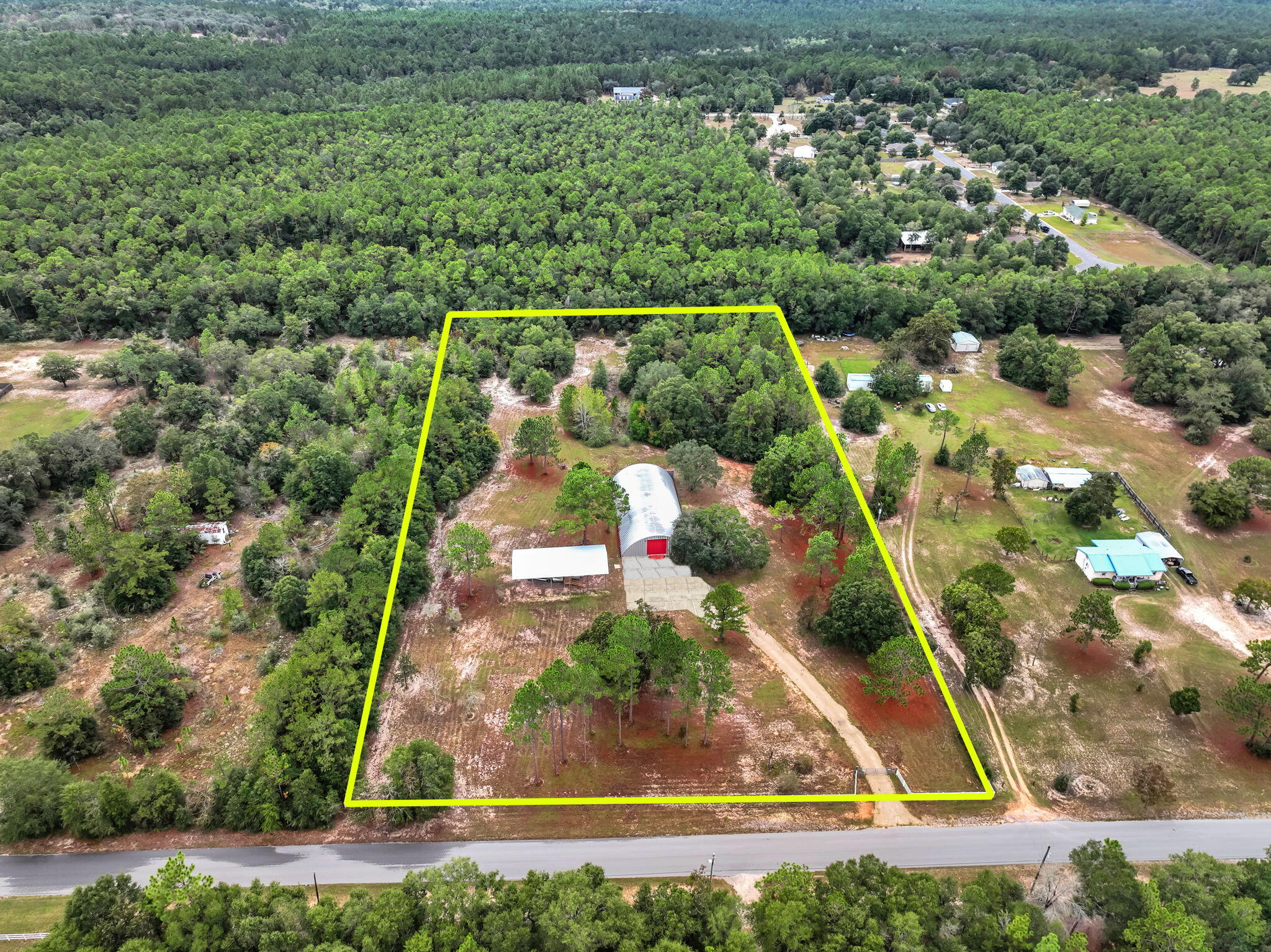 Located just outside the thriving Crestview corridor, this exceptional 4.47 acre property offers a rare blend of commercial flexibility and expansive outdoor space. Upon entering through newly installed electronic gates, you'll immediately appreciate the scale of what awaits: a 5,000 square foot Quonset hut set atop a 15 inch concrete slab, complete with a loading dock, full utility access, and a rooftop sprinkler system designed to moderate interior temperatures. Alongside the main structure sits a new pole barn sized for a 45 foot RV, and the site is further enhanced by two municipal water meters, a deep water well, two like new septic systems, and three full RV hookups including 30 AMP and 50 AMP service. Owner financing available up to 10 years.