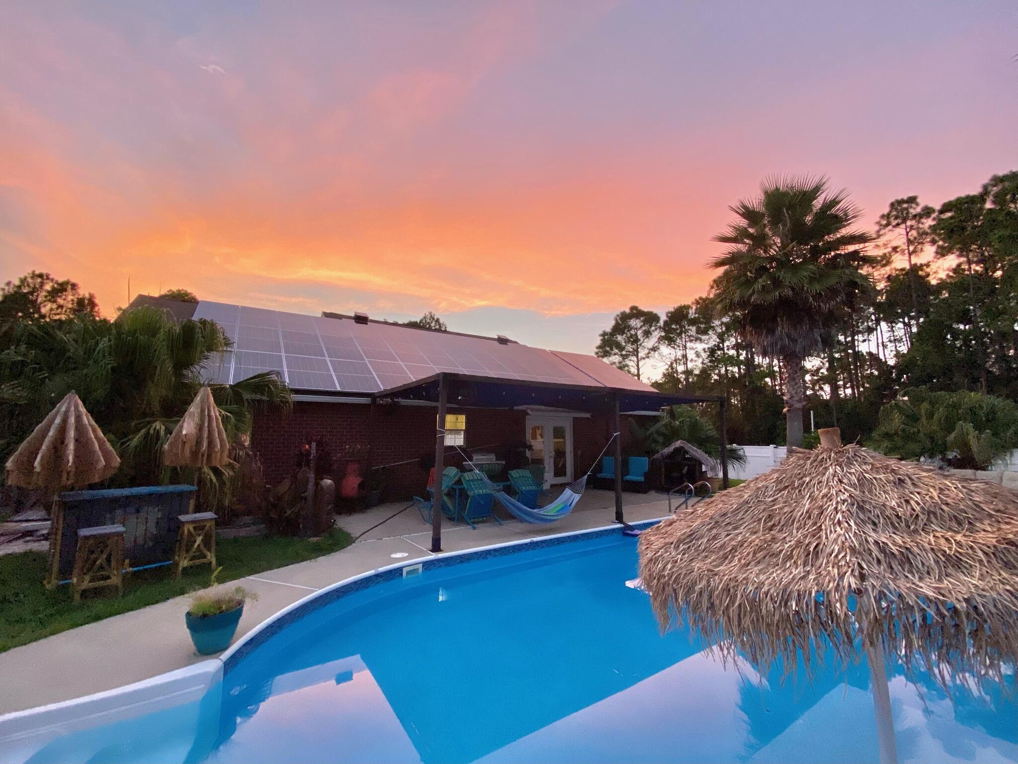 OPEN HOUSE Sat 11/19 & Sun 11/20 1:00 - 3:00. This is Florida living at its' very BEST! Fabulous Navarre POOL home perfect as a Vacation Rental or Primary home!
A stunning Tropical Oasis awaits in the fully fenced, big back yard and is so very perfect for entertaining and outside *FUN* with a large Saltwater Pool featuring a Swim Shelf and Bar; a Volleyball Court, large Workshop, a Tiki Bar and a large Pole Barn for your RV, Boat or Toys! This pretty home with great curb appeal, Palms and Tropical Plants, had a brand New Roof installed in October and features top of the line Tier 1, 2020 Solar panels that cover the entire electric bill and which will be paid off by the seller at closing. As you step through the Front Door, you will enter into the spacious and bright living area with its' high Vaulted Ceilings, Spanish Lace walls and beautiful tiled floors. The home features a split floor plan, a nice sized Master Bedroom and Bath with separate Garden Tub and Shower, plus his 'n hers Walk in Closets. The Kitchen has all Stainless Appliances, a Pantry and Breakfast bar, with French Doors leading out to the covered Patio and Pool from the adjacent dining area.  Other exciting updates and features include: a 2020 Solar/Elec water heater and 2020 2.5 ton HVAC system, an RV Pad with 50 AMP hook up AND septic/water connectors plus a level 2 EV charger and an Auxiliary Power switch for a portable Gas/Propane Generator. The home even has a Culligan whole home water softener System with Reverse Osmosis.  The Washer/Dryer, Smart Thermostat and Security Cameras all convey too! Great Location! Less than 10 minutes from Beautiful Navarre Beach with shopping and top-rated Navarre schools very close by, plus NO HOA!!
BACK ON MARKET DUE TO BUYERS FINANCING FAILING AT THE 11TH HOUR! Their loss could be your gain!!