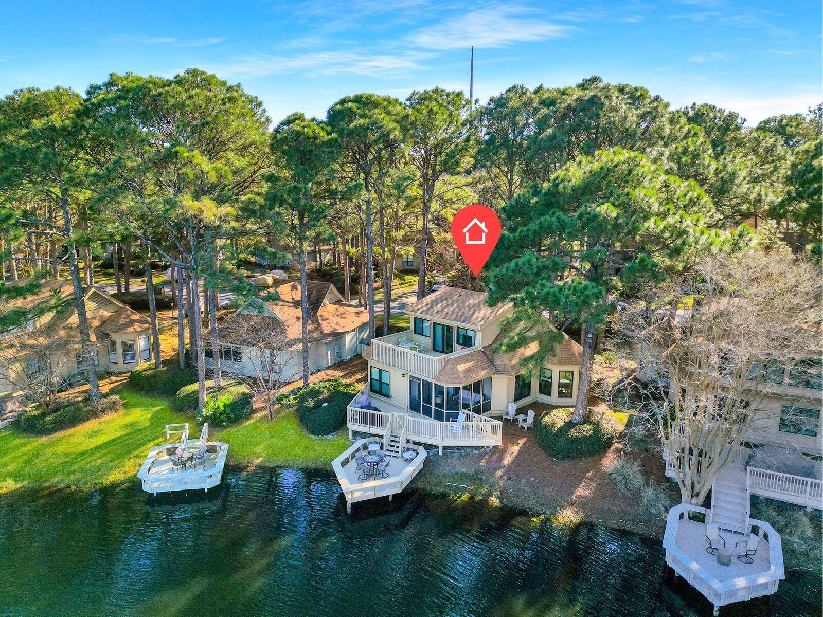 Lake front living in the heart of the Fairways of Sandestin! This 3BR/3BA coastal cottage delivers on everything you could desire  for the perfect home or a vacation rental. A private dock on the lake serves as the ideal spot to watch the sun rise or set in the distance after a long day at the beach.  An elevated terrace gives life to an outdoor kitchen, to grill up dinner al fresco, overlooking the lake. A third outdoor area, fully screened, will swoon you into a leisurely nap or entice you to curl up with a good book with tall mature pines swaying above.
Beautifully renovated, new kitchen appliances, quartz countertops, updated bathrooms, soft close cabinets, new exterior paint, and a new hot water heater add to this turn key two story cottage for easy living. With one Master Suite overlooking the quiet lake, no need to head upstairs.  The second Master Suite perched upstairs and perfect for guests, boasts it own private terrace alongside the lake with the sounds of the fountain flowing in throughout any given day.  This lovely home has not been on the rental program, but others in the neighborhood generate over $65,000.  Come see this today before it's gone!
