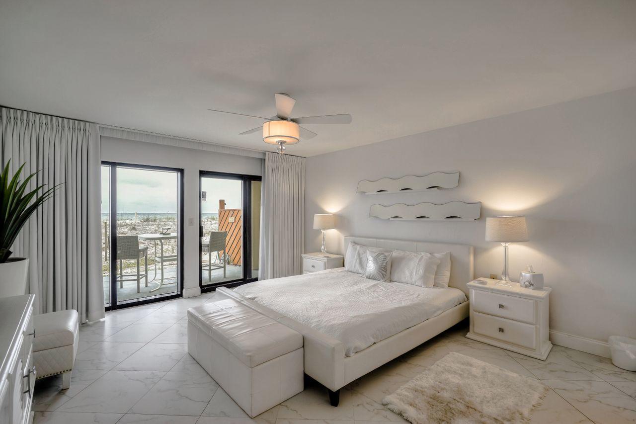 Welcome to your little slice of heaven along the beautiful Emerald Coast! This spacious 1st floor unit has gorgeous, unobstructed views of the crystal white sand beaches and emerald green waters of the Gulf of Mexico. Drive right up to your front door! No waiting in line at an elevator nor steps to tackle to take you to your unit. Slip through your master bedroom or living area sliding glass doors onto your 450 sq. ft. patio to enjoy a cocktail at sunset with friends and family with easy access to the dedicated beach walkover. The kitchen comes fully equipped with stainless steel appliances including refrigerator w/ ice maker, garbage disposal, dishwasher, self-cleaning oven, and microwave with a separate, adjacent laundry room as an added bonus with full-sized washer and dryer. The open living space includes a table for 6, small wine refrigerator, reclining leather sofa, custom 10x12 area rug, and a 50" television all creating a great oasis to relax at the end of a long beach day. The master suite is a fully-remodeled DREAM with king size platform bed, 36" television and a wall mounted heat/no heat sand designed fireplace. Floor to ceiling sheer and blackout window treatments provide incredible natural sunlight throughout the day while also providing a dark and cozy atmosphere for a good night's rest. The master bathroom comes equipped with a custom sliding barn door and a pocket door separating the updated vanity/closet space from the soaker tub/shower area for added privacy. The 2nd bedroom includes a queen size bed and an extra-long twin size bed with trundle and access to the 2nd guest bathroom. Investors have the easy option to rent this unit as a 1BR or 2BR unit. Surf Dweller amenities include a heated pool, fitness center, lighted tennis/pickle board courts, beach chair service w/ discounted fee, barbecue grilling area, parking garage and security cameras. Come check out this incredible unit today!