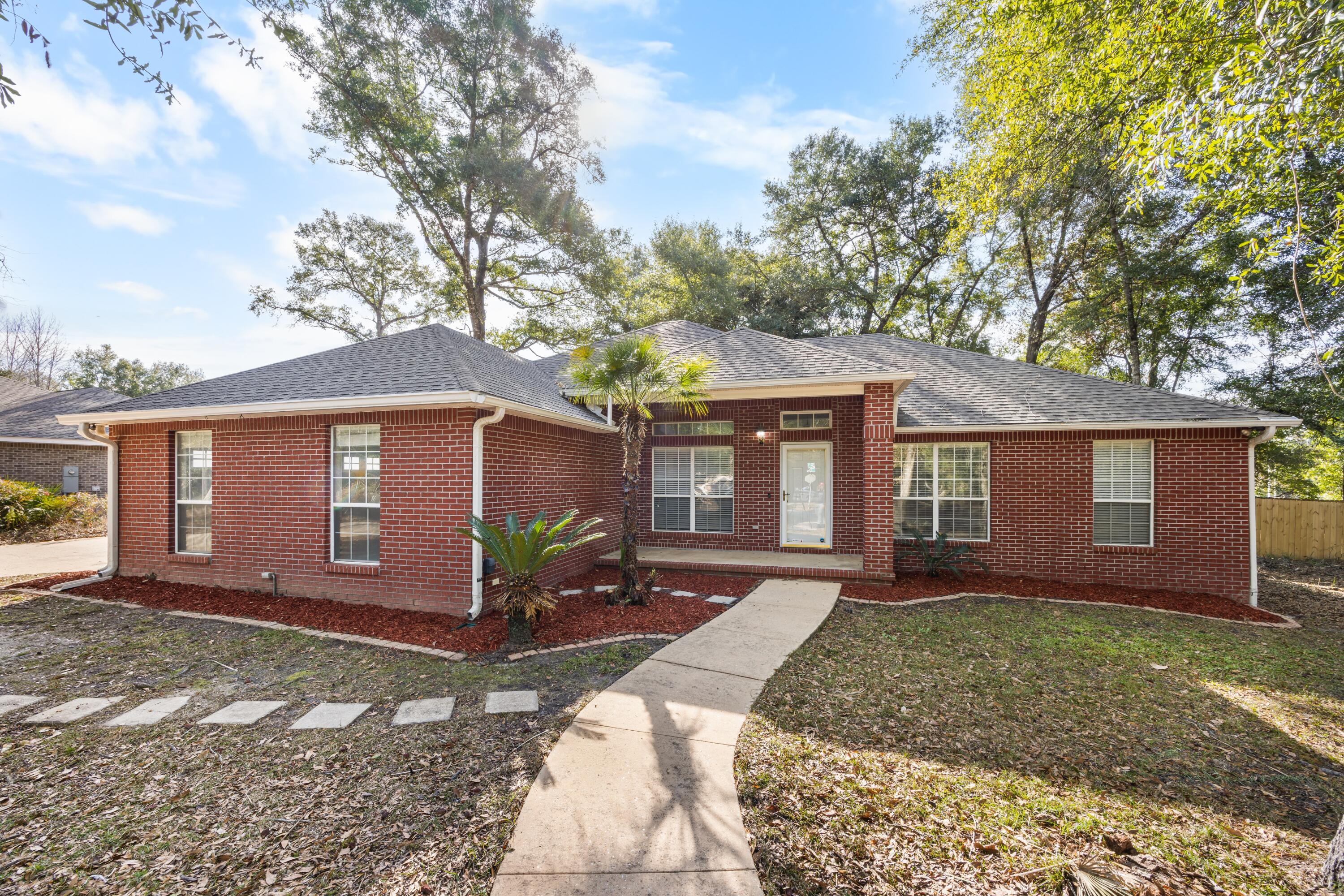 Welcome to 101 Eagle Drive, a beautifully maintained home situated on a nearly ½-acre corner lot on the desirable south end of Crestview. Ideally located just minutes from military bases, schools, shopping, and I-10, this property offers both convenience and privacy in a well-established setting.
Step inside to find hardwood floors, vaulted ceilings, plant shelves, and a cozy gas fireplace creating a warm and inviting entry. The bright, open kitchen features recessed lighting, custom all-wood extra-tall cabinetry, and under-cabinet halogen lighting, perfectly complemented by a sunny breakfast nook and a formal dining room ideal for entertaining.  An eye-catching office or bonus room showcases French doors and an embossed double tray ceiling, offering a flexible space for working from home or hosting guests. The split bedroom floor plan provides added privacy, with the spacious primary suite featuring private backyard access, a walk-in closet, garden tub, split vanities, and a separate shower. Secondary bedrooms include mirrored closets and share a convenient Jack-and-Jill bathroom. Outside, enjoy a large, flat, fully fenced backyard surrounded by mature treesperfect for relaxing, entertaining, or outdoor hobbies. Additional highlights include a roof replaced in 2021, brand-new chimney case, privacy fence replaced in April 2024, a recently renovated laundry room, and a backyard RV propane hookup already in place. This clean, move-in-ready home combines thoughtful updates, functional design, and a prime locationmaking 101 Eagle Drive a standout opportunity in Crestview.
