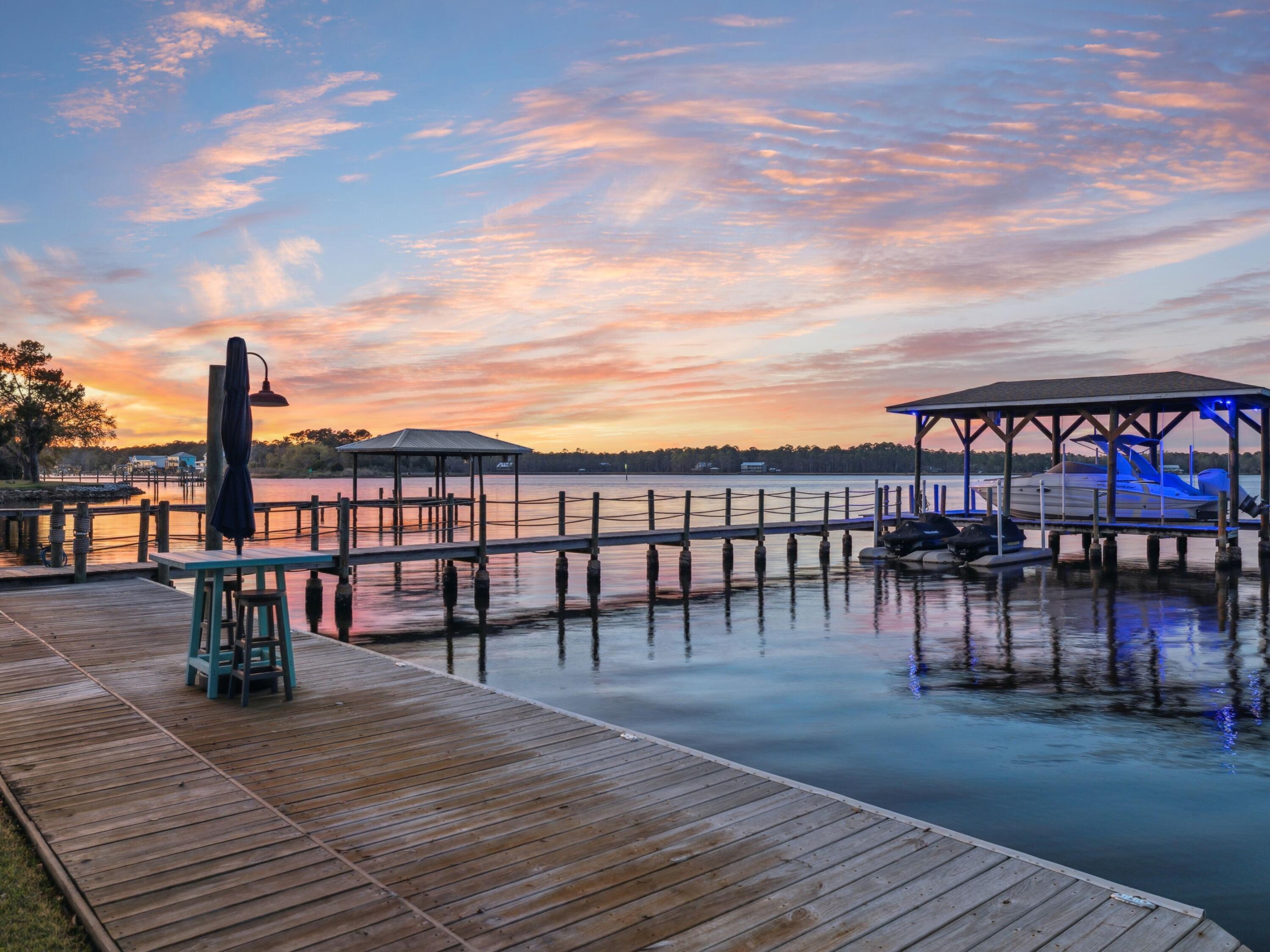 Live the ultimate waterfront lifestyle in this 2021-built Bayfront retreat, where newer construction meets deep-water access, a private dock and lift, and effortless access to the Gulf. Designed with the coastal boater in mind, this rare offering is perfectly positioned on 0.74 acres with 110 feet of Bay frontage, offering year-round 4-6 feet of deep water, no HOA, and just minutes to 30A. Whether you're cruising to Crab Island, paddleboarding at sunrise, or fishing the Intracoastal Waterway, every detail of this custom 4-bedroom, 5-bathroom home is tailored for luxury living on the water. The private dock has been fully upgraded with a 7,500-lb boat lift, Jet Ski floating dock, new electrical system, city water access, floodlights on timers, and snap jackets on the pilings for added durability. A private boat ramp makes launching kayaks and paddleboards a breeze.
The outdoor area is a true entertainer's haven, featuring a 30' x 15' saltwater pool with heating, cooling, and ultraviolet sanitation, plus a pool house with full bath, NatureKast cabinetry, and a large screened-in porch with wood ceiling and color-changing LED lighting.
Inside, enjoy Bay views from the main living spaces, a chef's kitchen with GE Café appliances, pot filler, wine fridge, and under-cabinet lighting. The spacious dining area easily seats 8-10, while the primary suite offers stunning water views, dual walk-in closets, and a spa-inspired bath. Each bedroom includes its own en suite bath, with one guest room offering a soaking tub and another with water views.
Additional features include smart home integration (HVAC, garage doors, built-in speakers), three garages, a mudroom/laundry with built-in workspace, and abundant storage.
This is more than a home,it's a lifestyle. Paddle. Cruise. Fish. Entertain. Relax. All with no HOA restrictions and direct access to Florida's best waterways.