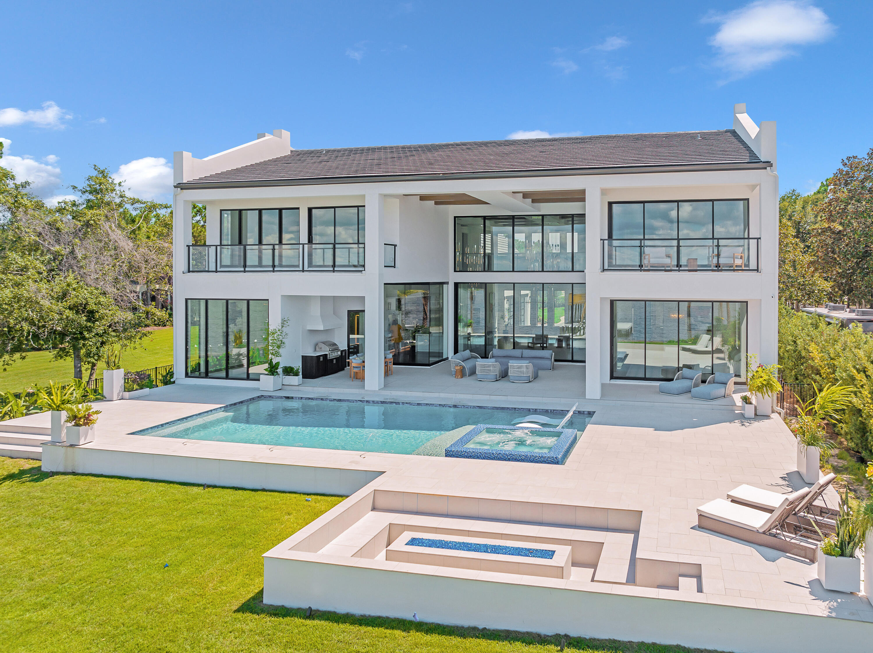 Imagine living in this prestigious custom-built home by renowned builder Norm McLean. Reached along a lengthy gated driveway, this recently completed coastal contemporary home occupies an oversized lot with a gated winding 400 ' drive and breathtaking 180-degree views across Choctawhatchee Bay. The private jetty awaits your boat and jet skis while the elevated deck provides compelling sunset vistas year-round. The white stucco home is softened with hints of wood and white brick while the metal and glass front door hints at the artful interiors yet to be revealed. A series of covered rear patios, porches and glass-enclosed balconies along with an astonishing two-story wall of glass deliver sensational bay views. The resort-style pool creates a focal point for outdoor living that includes a luxurious bubbling hot tub, sunken fire pit and outdoor kitchen. The dramatic beauty continues inside the great rooms soaring 24-ft. ceilings. The lofty space is softened by reclaimed cypress beams and sparkling contemporary lighting best appreciated from the dramatic steel-and-glass walkway on the upper floor providing added drama with industrial overtones. Natural elements are put to good use in the custom milled center cut red oak hardwood flooring, 10-ft. wood paneled doors and breathtaking two-story fireplace clad in quartz. The open concept kitchen continues to overdeliver with espresso and white floating Italian Milano cabinets which reflect a European inspiration while the quartzite-covered island creates a natural gathering place for casual dining and socializing. A Wolf range and kitchen-aid built-in wine storage are just some of the chef-worthy appliances. State-of-the-art features include a full-house SONOS sound system for playing your favorite music to suit all moods while the remote Lutron electronic system takes care of everyday tasks. Electronic blinds ensure privacy in the presidential bayfront master suite which has its own private patio. Like all the bathrooms, the first-floor master bath showcases stylish floating cabinetry and attractive tiles. The second floor has the same outstanding design quality and space with gorgeous guest suites, a second bayfront master suite and an Oscar-worthy screening room., and gym space. The four-car garage is accessed through fully retractable steel and glass doors and the final perk is no HOA.