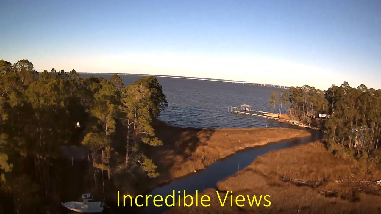 Build your dream home on the Emerald Coast. With almost an acre of land with mature trees, this property offers breathtaking views of the bay, 300 feet of water frontage on a creek with small watercraft access to the bay and then the gulf. Dock your small fishing boat, pontoon and jet skis and live like you're on vacation every day. Fine dining and the world's most beautiful beaches are a short drive away.