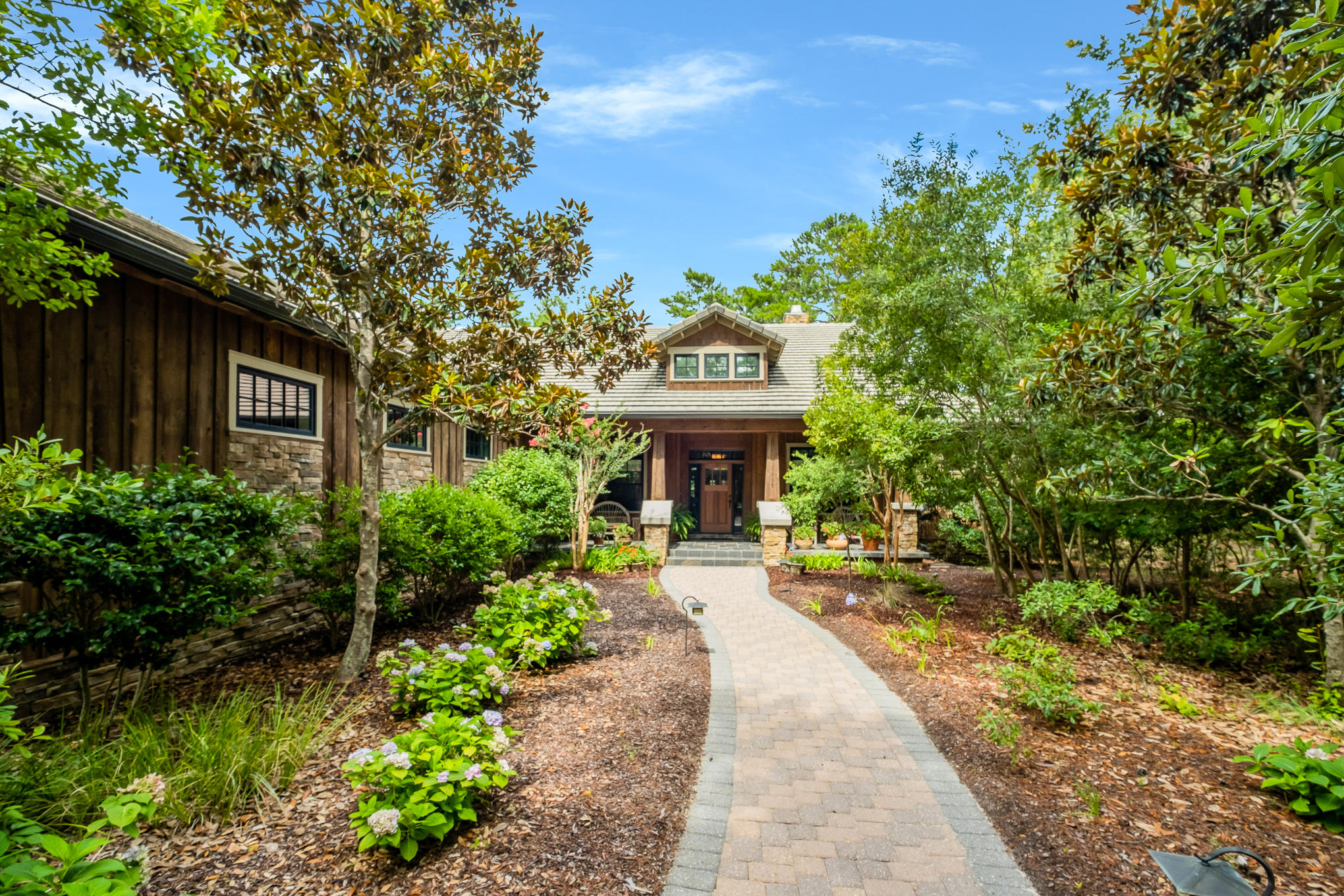 It's rare to find a quality custom-built home close to 30A in a peaceful community on a coastal dune lake with golf, but this craftsman home ticks all the boxes. Located on one of the larger lots in the gated community of Wild Heron, this secluded home boasts a sweeping brick paved driveway canopied by beautiful trees and a 3-car garage with ample coveted storage. Reflecting its unspoiled surroundings, this home makes extensive use of natural materials. Check out the imposing mahogany front door, stacked stone columns, cedar siding, wood-clad windows, concrete roof, slate tile and rich Brazilian hardwood floors. 

Well maintained, this bespoke home has custom kitchen cabinets, granite counters and a bevy of stainless Kitchen Aid appliances including an ice machine, wine refrigerator, warming drawer and 5-burner gas stove. Keen chefs will delight in the large pantry and center island prep space.It's ideal for large-scale entertaining as the kitchen easily flows to the open areas of the living and dining room, but you might prefer a casual cook-out on the lengthy screened porch with natural gas grill and surround sound. New paint, a/c and Rinnai tankless water heater reflect the excellent condition, allowing new owners to add their own personal touches and updates. 

The traditional Great Room with 12-foot wood stained ceiling is a space for relaxing in front of the stone gas fireplace flanked by craftsman-built bookcases or enjoy a book or work from home in the connecting study and office space which could also be used as an additional bedroom.  A series of French doors deliver ample natural light and a seamless transition onto the screened porch with beautiful pond views. Move into the master suite to find trey ceilings, sitting area with French doors that open to the screened porch, his 'n' hers California Closets, whirlpool tub, large walk in shower, twin vanities and water closet.  Two additional bedrooms, one that opens to the screened porch, each with their own en-suite baths with walk in closets, a half bath and laundry area that connects to the garage, completes the single level split floor plan of this home.

Outdoors, this private lot is professionally landscaped yet retains a sense of untamed wilderness that characterizes this exceptional community. Backing onto a natural pond stocked with fish, it's a delightful habitat for local birds and wildlife. This outstanding quality home nestles within a 734-acre coastal sanctuary with Greg Norman golf course, tennis, 24 miles of walking/biking trails, fitness center and community pool. With boat docks, kayaks and amenities on Lake Powell, the outdoor Florida lifestyle begins right here.