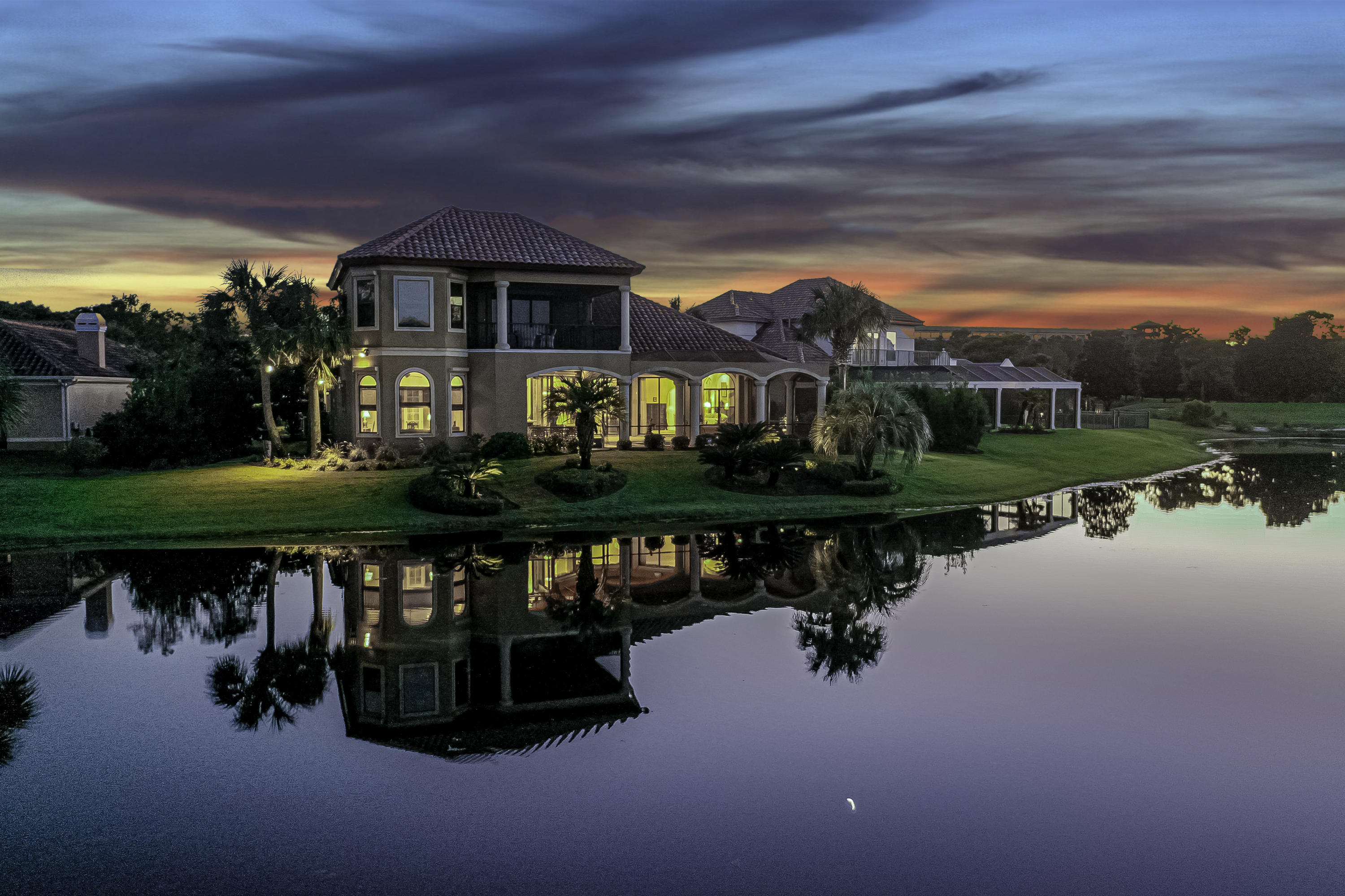 Stunning Mediterranean home ideally situated on one of Regatta Bay's premiere lots. Enjoy overlooking the lake and golf course while lounging in the oversized lanai complete with an outdoor kitchen and fireplace, as well as a heated pool with fountain. Exterior landscaping is ripe with lush tropical vegetation surrounding the property providing privacy without obstructing views. This is year-round Florida living. Downstairs has 3 bedroom and 3 baths including the master. Upstairs are two additional bedrooms with en suite baths that lead out to a large covered wrap around porch to catch the astonishing vistas.