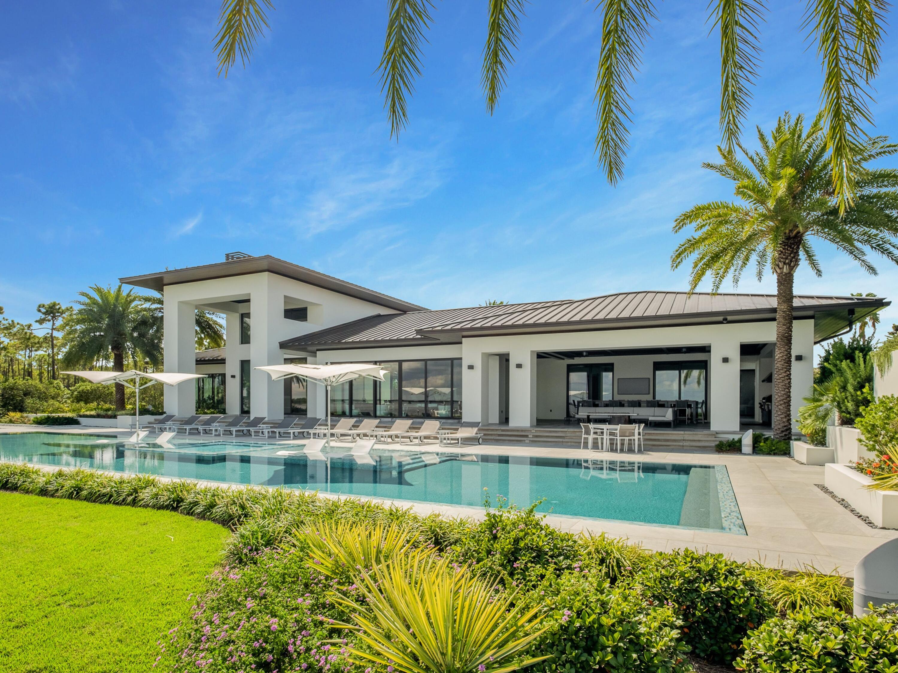 Idyllic in locale, construction, and architectural significance, this majestic bayfront legacy property provides the ultimate in fit, finish and experience for all who spend time enjoying the grounds. Encompassing an irreplicable 278 feet on the Choctawhatchee Bay, this 7,269 square foot enclave provides uncompromising privacy, while placing imported materials and grand scale at the forefront of the home's highlights. Upon entry, through the pivot hinged custom steel frame french doors, a welcomed sense of arrival is felt through the vaulted ceilings with custom mahogany accents, oversized 22-foot wide fireplace, and mesmerizing large format television, all framed in with direct views of the bay through nearly 100 feet of floor to ceiling windows. Four bedrooms, each with grand ensuites make up the main house, including the attached 2,284 square foot garage with 4 separate bays. Three bayfront bedrooms provide uncompromising vistas of the enchanting waters, while the open concept living space takes full advantage of the natural light dancing across the imported La Fabbrica tile flooring, showcased throughout the home. The master bedroom retreat provides a true oasis accented by an expansive walk-in shower, custom closet, thick-cut quartzite-clad dual vanities, and a private laundry set up for the ultimate modern-day convenience. The fifth bedroom with ensuite bath is available in the attached guest suite, offering a private space perfect for a game room, workout area, or art studio. Lifestyle amenities such as the 88-foot perimeter overflow saltwater pool, private dock with boat lift and jet ski docking, covered patio with Wolf outfitted summer kitchen, and a conversation pit-inspired bayside lounge space ensure relaxation and entertainment opportunities are never in short supply. Additional details such as Sistemalux outdoor lighting, Rocky Mountain Door and Cabinet Hardware, Iguzzuni LED lighting, whole-home generator, and Control4 smart home system come together to provide a contemporary take of coastal luxury, unlike anything seen elsewhere along the Emerald Coast.