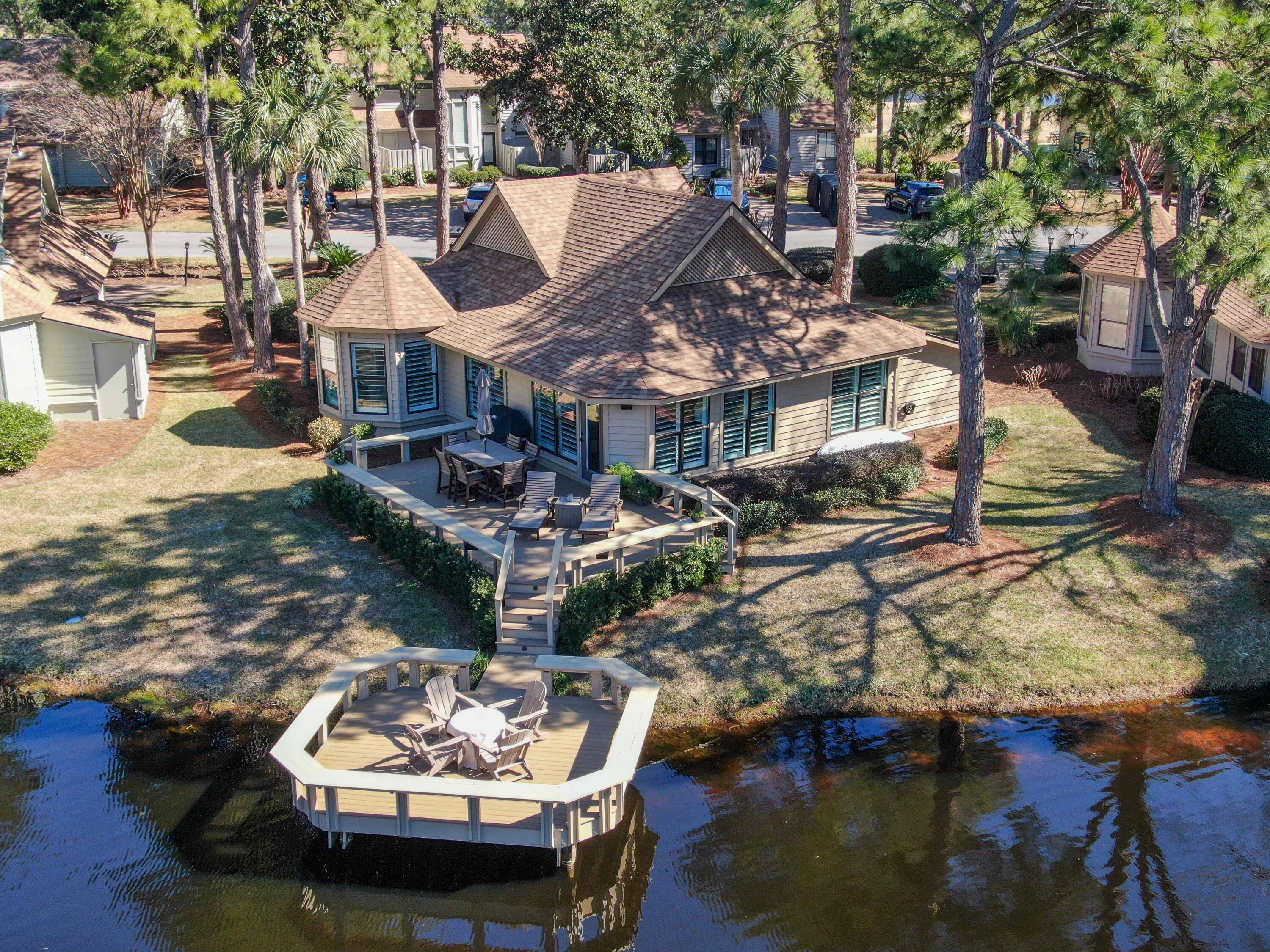 ARE THOSE DIAMONDS IN THE POND? Be careful, the waterview can be somewhat mesmerizing and the appearance of sparkling objects may draw your gaze for long periods of time. And, this detached home comes with optimal means of enjoying the view: an oversize patio and a dock! The dock is a perfect place to fish or enjoy the firepit, and the patio is equipped with a durable POLYWOOD DINING SET and 2 LOUNGE CHAIRS.  Adding to the experience are MARTIN LOGAN outdoor speakers that fill the air with high-end acoustic sound. 
Although built in 1982, the sensation of stepping into a new home will be perceived at the driveway.  The complete updating/renovation process began 4 years ago when the owner replaced the flooring and enclosed the back patio. However, once the current owners purchased the home, the renovations marched on at a fever pace.   New barn doors were installed.  All walls were painted.   New lighting and hardware were replaced.  The Kitchens and Bathrooms were remodeled.  Plantation shutters were installed.  Shiplap and Crown molding were placed throughout the entire home. Pocket doors were inserted. The HVAC was replaced, and a Bluelight/UV system (eliminates potential odors) was added. The exterior had a facelift as well with the addition of new paint, a new roof, and TREX decking on both the front and back patios/porches. Outdoor lighting (you gotta see this home at night), landscaping and Polywood furniture were also nice touches that rounded out the complete renovation.  Not only are the upgrades spectacular, but it comes fully furnished, and it's the "good stuff".  STOCK AND TRADE, HAVERTY'S, HANK'S FINE FURNITURE pieces fill this home and create an elegant, yet homey feel (a complete list in the Document(s) tab).  In total, the current owners have invested over $240,000 in updates/renovations and furniture.  
Located in the world renown Sandestin resort, this pristine home is being sold fully furnished and is turnkey ready and would make a perfect primary, secondary or short-term vacation rental. Sandestin Resort living offers gorgeous beaches, endless shops, gourmet dining, living entertainment, golf cart transportation, outdoor activities (including Pickleball courts!) and much, much more!