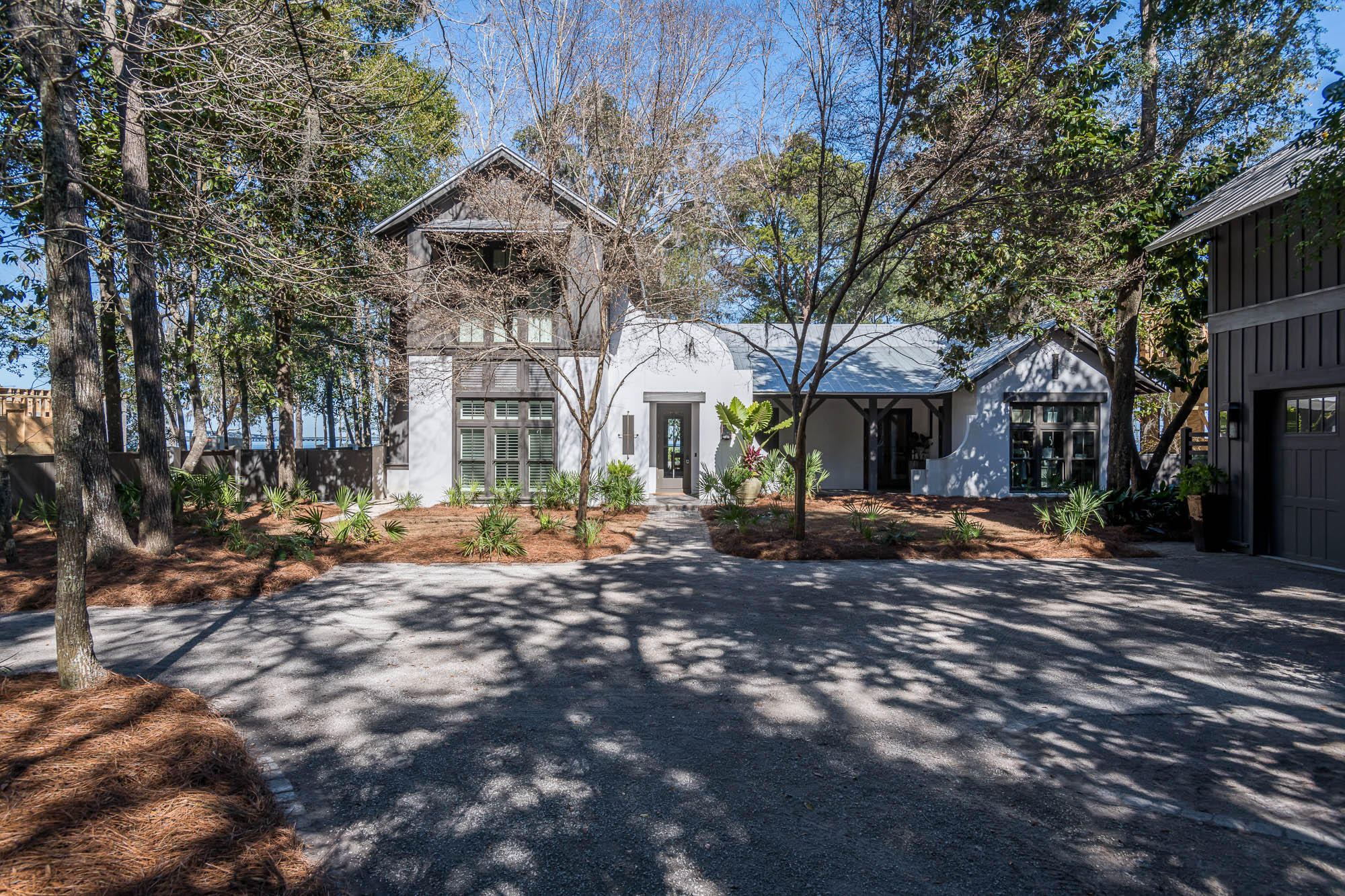 This stunning, custom designed home by architect Tammey Massey is nestled within the serene gates of The Estuary on 106ft of bay frontage. This bay front, coastal estate was thoughtfully designed and crafted with fortified concrete block constructed and built by the Arkon Group. The home offers an elegant open floor plan with a foyer that immediately offers direct bay views as you enter the living room, open dinning, and kitchen. The home has reclaimed distressed heart of pine floors throughout, vaulted ceilings, and open shelving in the custom designed chefs' kitchen that offers incredible panoramic views while mastering your favorite meals in this stunning kitchen. The most incredible and unique part of this timeless estate is the lush, tranquil backyard with a dark water pool, newly renovated boat dock, and slip that accommodates up to a 24-foot boat, with incredible bridge and bay views as far as the eye can see. Enjoy an afternoon poolside or a sunset evening fire side. This home also offers his and her office with custom built-ins, one with a full ensuite bath and the additional with a half bath. The Master suite is located on the first floor with incredible bay views, walk-in closet, soaking tub, separate shower, and marble double vanity. With 5 full bedrooms and 5.5 baths this home meets all your needs. The 5th room is located over the custom craftsman style oversized two car garage and carriage house that also provides additional storage. This is truly a one-of-a-kind home.  Do not miss the opportunity to own this beautifully designed bay front coastal estate. Buyer to verify all dimensions