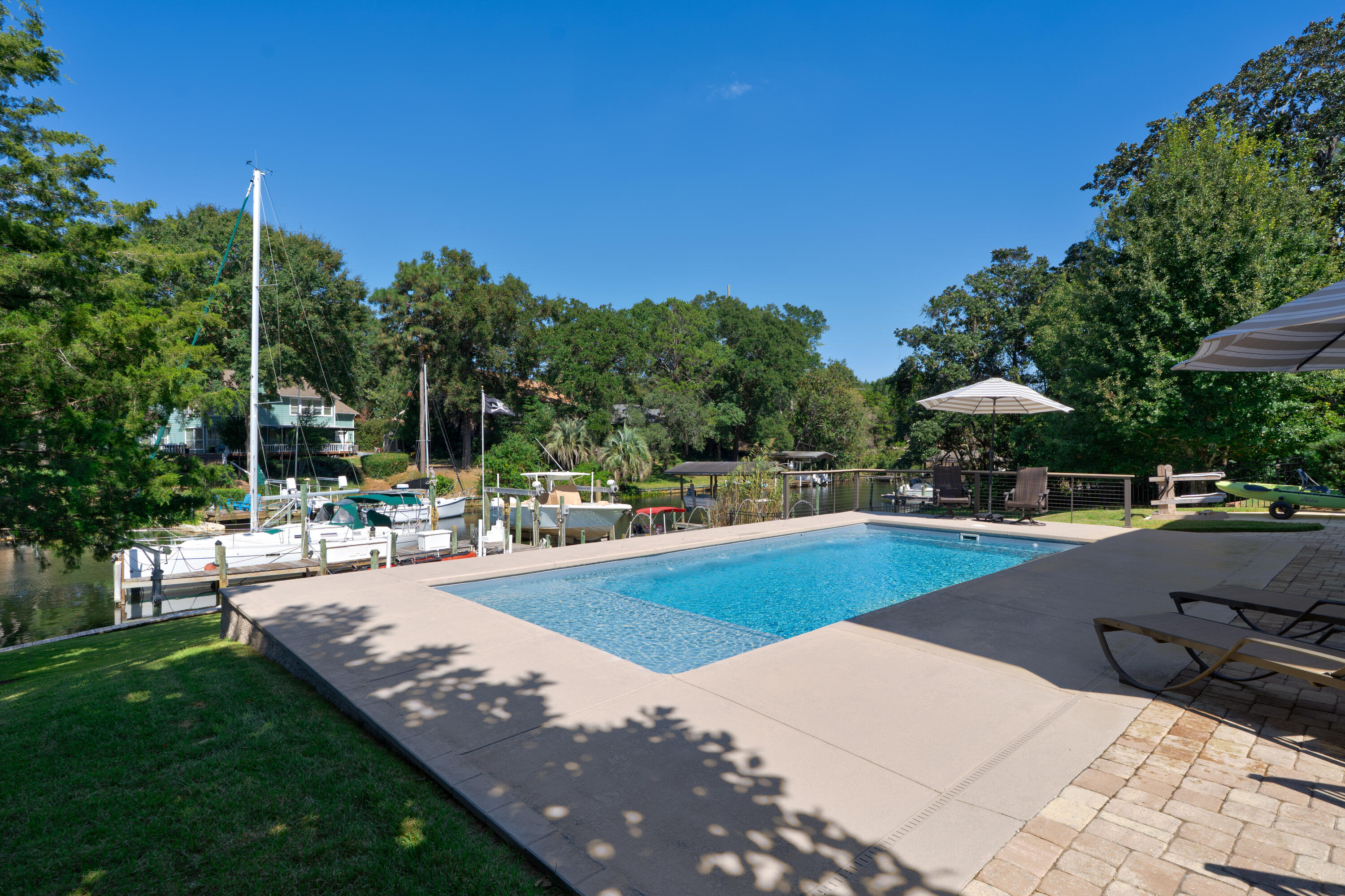 Boater's paradise! Flood zone X, 2018 construction with 80' of waterfront on a deep water canal with multi-boat dock and 16,000 lb boat lift. Home features a main floor and a walkout basement, each with a large screened Trex deck porches, overlooking the water and the fiberglass heated and cooled pool. 3-car garage on the front of the house + 40' deep garage on the back lower floor.
Porcelain wood look tile on main floor, high-end stainless steel appliances and gas stove (fridge 2024), both screened porches piped with gas hookups, all impact glass, plantation shutters throughout, two ventless gas fireplaces. Pool 2023, boat lift 2019, Generac 2018, 2 tankless WH, 2 HVAC, 2 PEX manifolds, 2x6 construction + spray foam in walls and ceiling excl gar, aluminium fence 2023