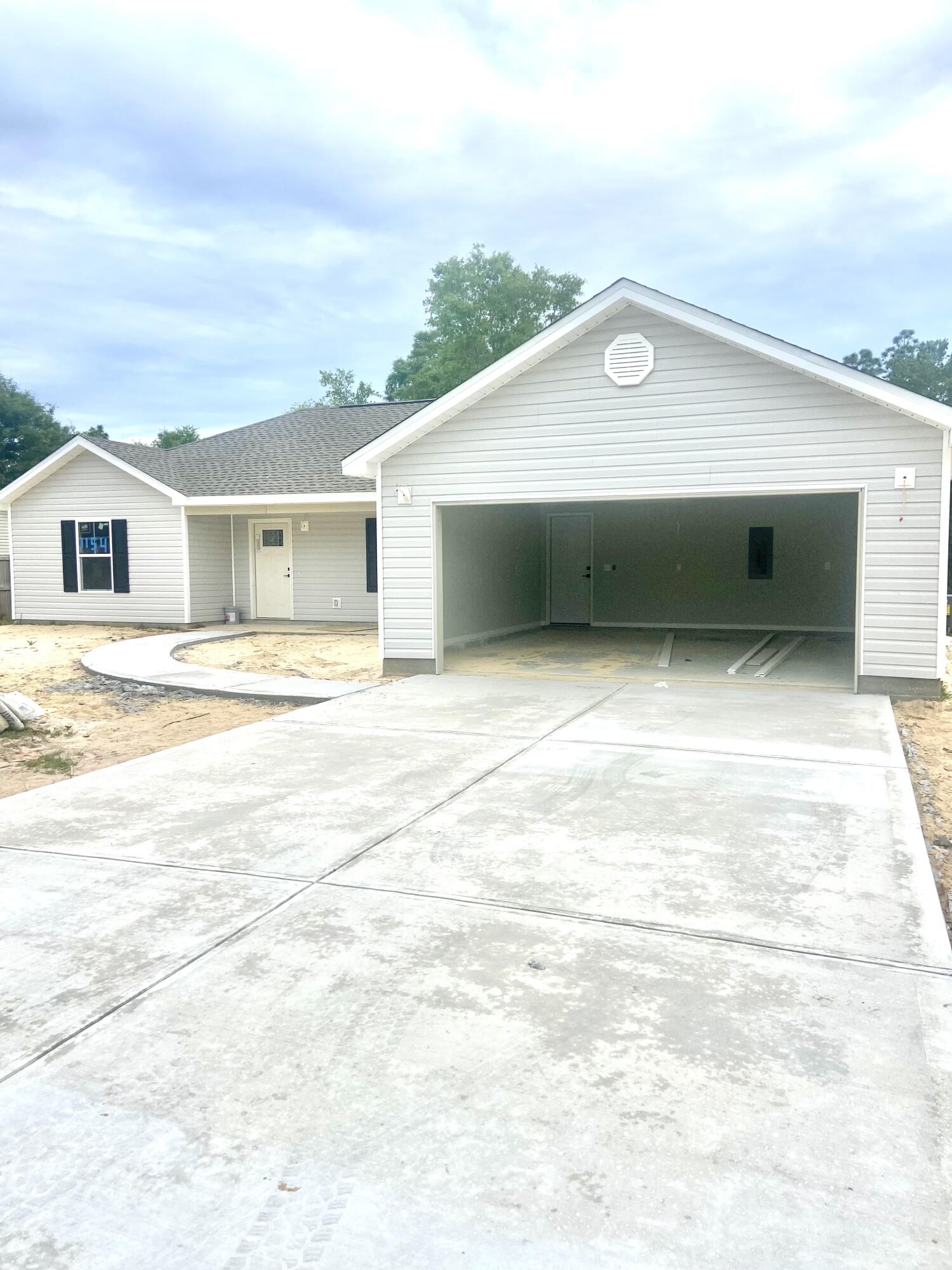 This home sits directly on the main road of Oakwood Lakes Blvd in the desired area of Defuniak Springs. Defuniak offers alot of history, as well as alot of new development. With this homes location you are minutes from all the local stores and restaurants. Did I mention it is NEW CONSTRUCTION?! This new home features gray vinyl siding, black shutters, cathedral ceilings, a tray ceiling in the master bedroom, a nice master bathroom with a large walk-in closet, a total of 3 bedrooms, 2 full bathrooms, stainless steel appliances, matte black finishes, LVP flooring throughout, white cabinets, granite countertops, a front porch to drink your coffee + a concrete pad out back to grill up some supper. Plus, it has room to play outside with it sitting on a .49-acre lot that kisses the water.