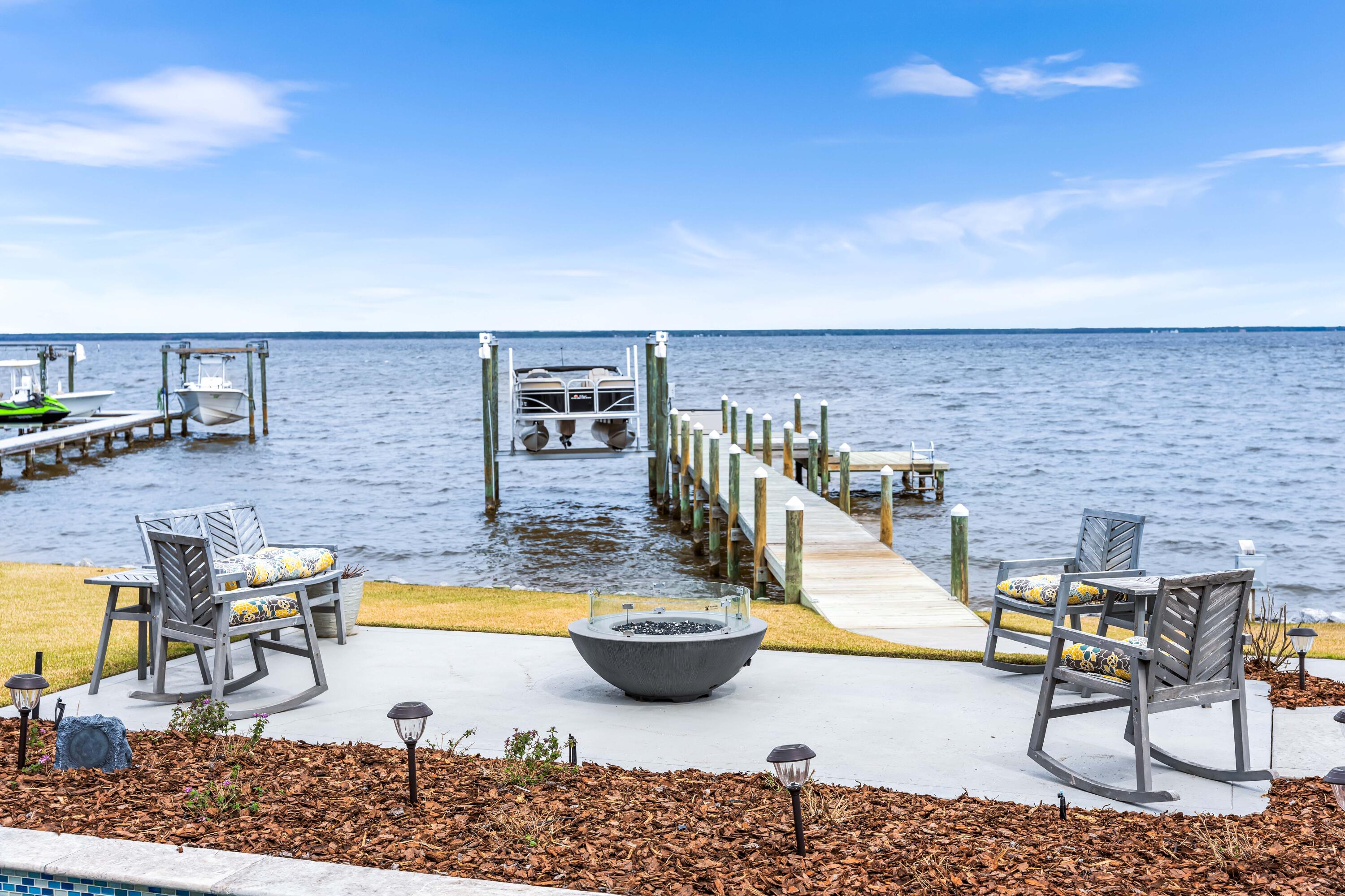 Welcome to your dream retreat ON THE BAY! This exquisite custom design build by Romair Construction offers unparalleled luxury living, complete with its own private boat dock featuring a swim platform and 6,000 lb boat hoist. Step inside to discover an inviting open floor plan designed for effortless entertaining, highlighted by expansive windows that flood the space with natural light and showcase breathtaking views of the bay.
Indulge in the comforts of a spacious primary en suite, featuring a luxurious tile shower, double vanity,  and an expansive walk-in closet. Enjoy direct access to the incredible backyard oasis, where you can unwind and soak in the stunning sunsets. With four bedrooms, two of which offer captivating bay views, and one currently used as a dedicated home office, this home provides ample space for both relaxation and productivity.
The heart of the home is the gourmet kitchen, complete with a large island for casual dining, generous cabinetry, and premium appliances. Adjacent to the kitchen, a sizable dining area perfect for hosting gatherings and creating lasting memories with loved ones.
Enhancing the allure of this waterfront haven are the thoughtful additions of a cozy fireplace, perfect for cozying up on cooler evenings, ADA accessibility throughout and a whole house generator, ensuring peace of mind during any unforeseen power outages. Featuring a large drive-way and an oversized two-car side entry garage equipped with an electric lift for attic access, you'll not only have ample space for your vehicles but also an easy solution for storing your belongings.
Conveniently located just minutes from the beach, premier shopping destinations, and a myriad of dining options, as well as a short boat ride away from Destin's beloved attractions like Baytowne Wharf, Northbeach Social, and Lulu's, this home offers the epitome of coastal living. Welcome home to your sanctuary by the bay!