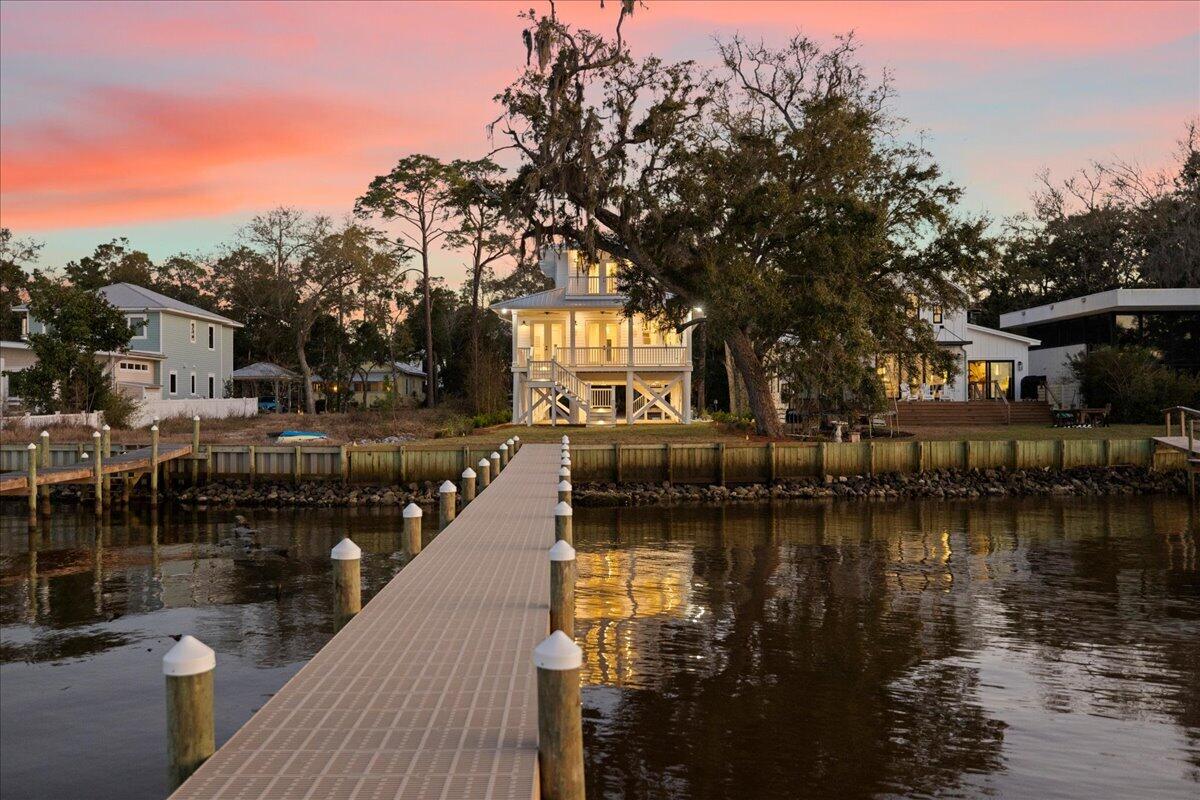 Welcome to 115 Native Tree—where classic Florida cottage charm meets modern sophistication. Perched on pilings in a nod to Old Florida's timeless design, this home is elevated to capture breathtaking bay views while offering future possibilities for its new owners. Whether you envision a garage, additional parking, or racks for your surfboards and paddleboards, the raised foundation provides flexibility for your coastal lifestyle or just enjoy the stunning bay views.  

Inside, the warmth of white oak flooring flows throughout, leading you to an open-concept living space where the custom designer kitchen with Thor appliances overlooks the bay and seamlessly connects to an expansive rear porch—perfect for taking in those iconic waterfront sunsets.

With four bedrooms and four baths this home exudes effortless style, infused with a subtle Australian-inspired flair. The custom all-oak staircase is a true masterpiece, anchoring the home's impeccable craftsmanship. Every bathroom features designer tile and quartz countertops, creating a luxurious yet inviting atmosphere.

Every detail has been thoughtfully curated, from the professionally landscaped grounds to the lighted steps and irrigation system. 115 Native Tree is more than a home; it's a work of art designed for those who appreciate classic beauty with modern comfort.

All information is deemed reliable and provided for informational purposes; buyers are encouraged to independently verify all details.
