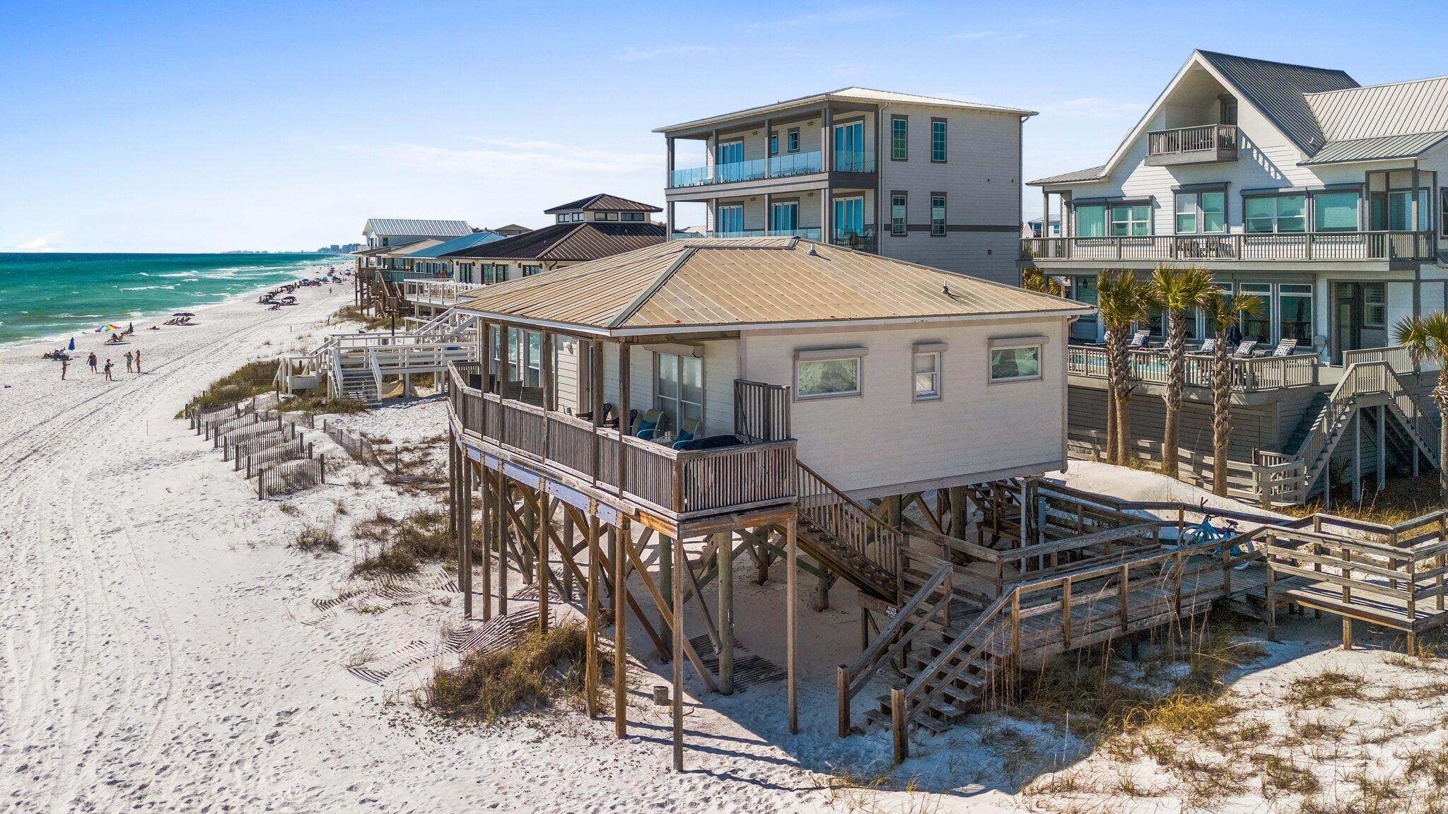Set on a prime Gulf-front lot along the West End of 30A, this classic beach cottage offers a rare combination of privacy, character, and uninterrupted views of the emerald Gulf and sugar-white sands. Tucked away from the main thoroughfare but still close to top-tier dining, shopping, and outdoor destinations, the property blends timeless Old Florida charm with the best of coastal living.

Designed with simplicity and comfort in mind, the cottage features two well-sized bedrooms — each with its own ensuite bath — and an open-concept main living area that maximizes both space and views. Natural light floods the interior through large windows, creating a relaxed, airy atmosphere ideal for a true beach retreat. Whether cooking in the efficient, well-equipped kitchen or relaxing in the living space, you're never far from the Gulf's presence.

Outside, a covered porch offers a quiet place to enjoy morning coffee or evening breezes, while a dune-front deck brings you even closer to the shoreline. With private beach access just steps from the door, days here move at the pace of the tideeasy, calm, and grounded in nature.

Offered fully furnished and including a complete set of architectural plans for a future build, this property is ready for immediate enjoyment or long-term vision. Whether you're looking for a peaceful getaway, a strong investment property, or the perfect site to build a custom Gulf-front home, this is a rare opportunity to own a piece of 30A with both charm and potential.