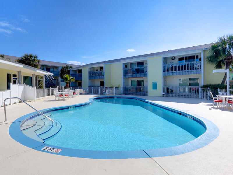 Welcome to your own slice of paradise on Pensacola Beach! This stunning 2 bedroom, 2 bathroom condo is located in the heart of Pensacola Beach, just steps away from the crystal-clear waters of the Gulf of Mexico.

As you enter the unit, you'll immediately love the soft, coastal color pallet and coastal décor. Lots of NEW features to appreciate to include NEW furniture in 2022, NEW HVAC (2022), NEW water heater (2022), NEW carpet (2022) and NEW windows installed by the Association within the last 6 months. The spacious living area is perfect for entertaining guests or relaxing after a long day at the beach, and features plenty of natural light, comfortable seating, and a large flat-screen TV.

The kitchen is fully equipped with all the stainless steel appliances, counterspace with granite countertops and cookware you'll need to whip up delicious meals for your family and friends. The dining area comfortably accommodates your guest.

The master bedroom boasts a king-size bed, a large flat-screen TV, and an en-suite bathroom with a walk-in shower. The second bedroom features a full bed, queen size bed, a flat-screen TV, and easy access to the second bathroom.

Step outside onto your private balcony and take in the sights and sounds of Pensacola Beach. Enjoy your morning coffee or a sweet tea while watching the sunrise and sunset over the Gulf.

The condo also offers convenient amenities such as an on-site pool and outdoor grill area, as well as covered parking for one vehicle.

Located just a short walk or bike ride from Pensacola Beach's best restaurants, bars, and shops, this condo is the perfect place to call home during your next beach vacation. Don't miss out on this incredible opportunity with great rental potential too!