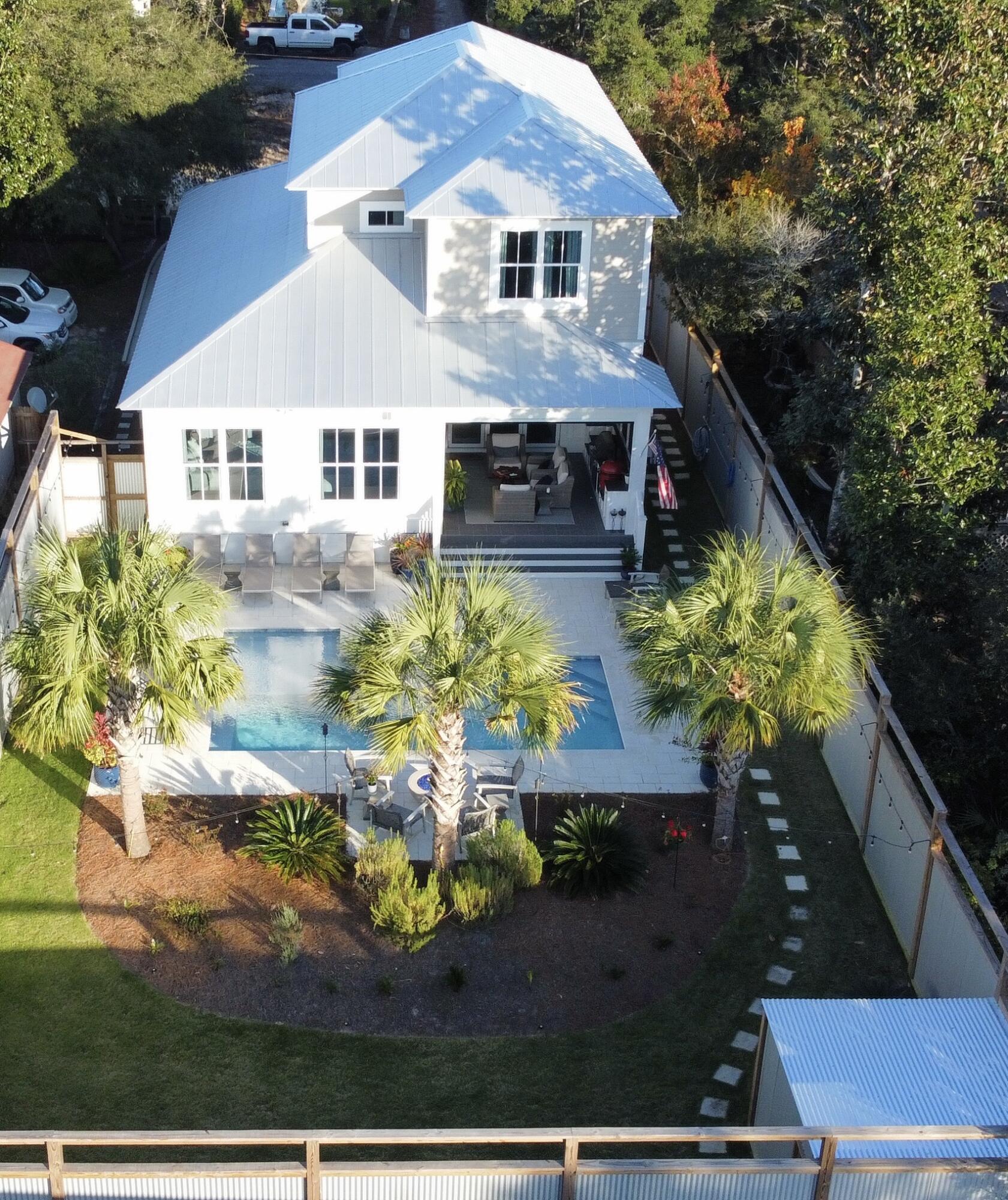 As you walk into this custom build you'll enjoy open living at its best.  Upon entering the living room you'll see through the open concept straight to the large porch with remote mobile screen opening to the large pool and lush private back yard.  In the back  you have your very own private oasis complete with covered summer kitchen and gas firepit.  Back inside you'll enjoy a chef's kitchen with Thermador appliances and 11' island for great prep space and dining, a wet bar with Scotsman ice machine and wine fridge.  Large primary bedroom and spa bath are also on the main level.  Upstairs you'll find three bedrooms with private baths.  One of the bedrooms has custom built queen over queen bunks.  This home feels so spacious and every inch inside and out has been thoughtfully planned.