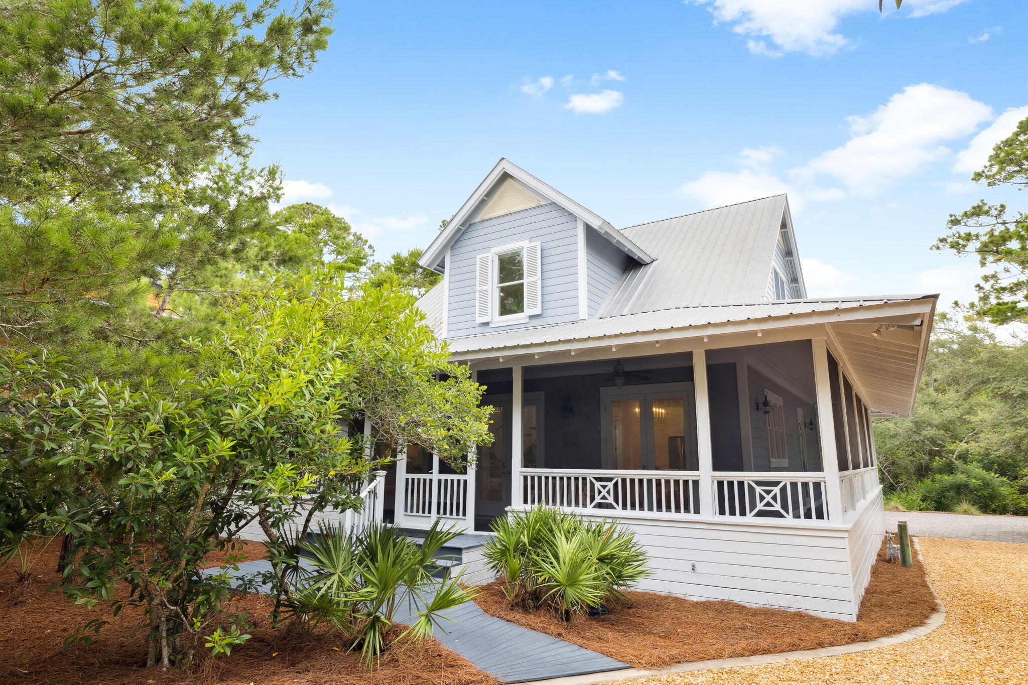 Don't miss this opportunity at 385 Wilderness Way to embrace the 30A lifestyle among 20 lush acres! Live and play in the gated, tranquil neighborhood of Lake Place at Grayton Beach situated between 30A and Western Lake with private neighborhood dock and sparkling pool.  Welcome to a beautiful bright and airy coastal retreat with carriage house.  This charming Florida cottage at once welcomes you and embodies the laid-back vibe of Grayton Beach while sitting prominently on a large homesite with well-maintained indigenous landscape of magnolia, twisted oaks sculpted by southern breezes, tall pines, and bright green palmettos. Outdoor living abounds on the large, screened wrap around porch. This home offers a blend of privacy, modern amenities, and proximity to the natural beauty of acres of forest trails, bike path, state parks and Western Lake, a rare coastal dune lake. The main house features a spacious wrap-around screened porch, ideal for enjoying the serene surroundings, an eat-in kitchen with gracious countertop space and window over the sink, built-in bookcases and tall ceilings, plus an outdoor area ideal for grilling. It includes two bedrooms and a bathroom on the first level, with a full second level primary suite and loft for workspace. The Carriage House (built in 2019 according to public record) features private porch, living area with sleeping, full bath, kitchen plus washer and dryer making guest life easy. Enjoy convenient garage parking plus room for stowing away kayaks, standup paddle boards and bikes. The home is set back among native landscaping, offering privacy in a 20-acre, rental-restricted neighborhood featuring 50 home sites with access to a community dock on Western Lake and a neighborhood pool. Just minutes from the Gulf of Mexico, residents can enjoy sunsets over the lake, kayaking, paddleboarding right off the community dock or relaxing by the sugar-white beaches of Grayton Beach State Park.  Nature trails connect Lake Place to the forest for a walk with nature and state park passes are easily available for beach access or kayak or canoe to the beach.  Visit Grayton Corners or Uptown Grayton both within walking distance and feature a myriad of shopping, eateries and more.  We invite you to discover the gem of Lake Place at Grayton Beach, 385 Wilderness Way. It's all here waiting for you at 385 Wilderness Way.