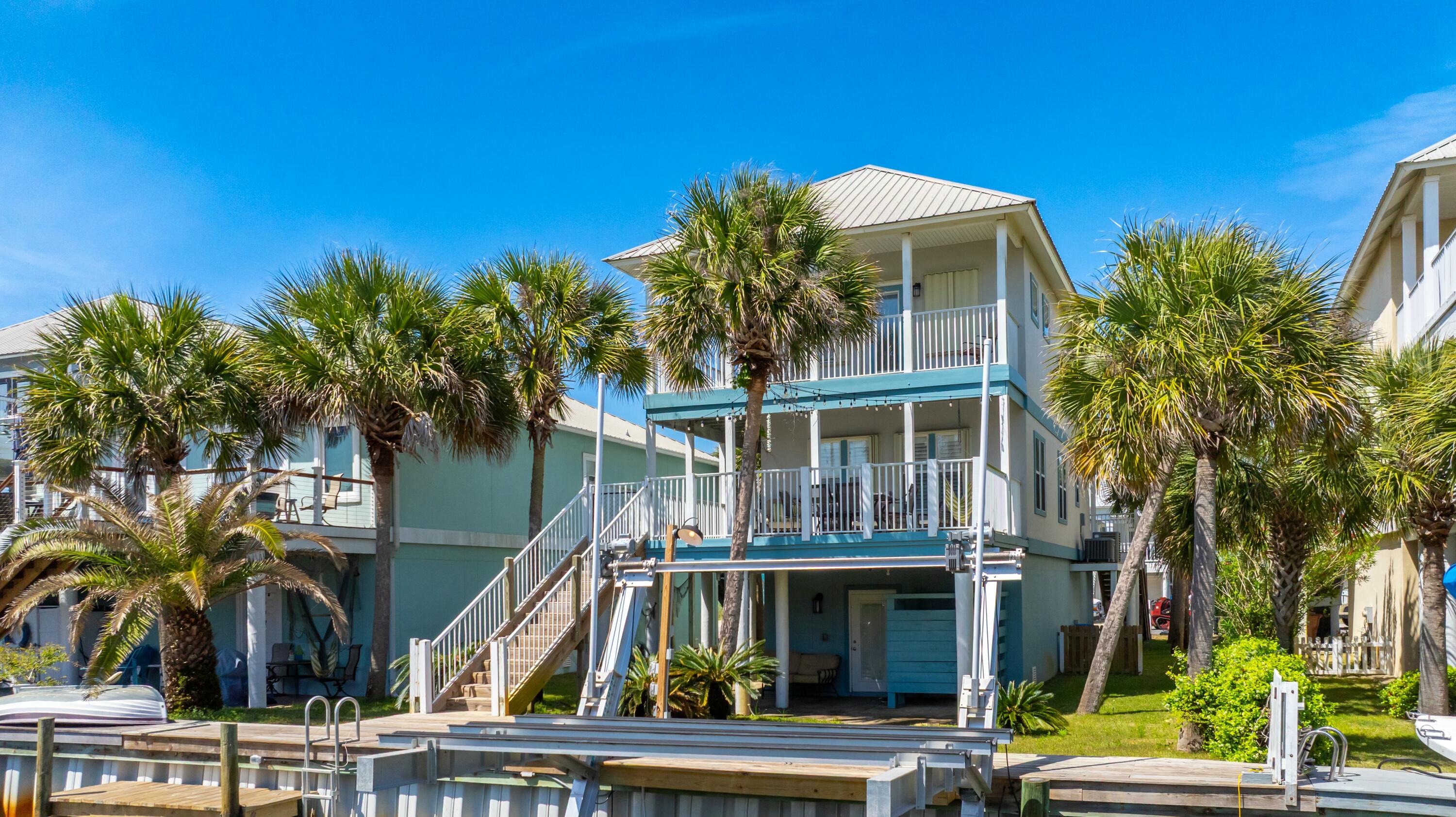 INVESTORS, NOW IS YOUR CHANCE!  BACK ON THE MARKET AT NO FAULT OF THE SELLERS AND WE ARE READY FOR YOUR OFFER!  Welcome to Homeport!  A community that has access to all of your families favorite things about Navarre Beach!  This 4 bedroom, 3 bathroom Canal front home has a new boat lift installed in 2023, two double length garages, gorgeous outdoor living space and is just across the street from the community pool!  You can play all day in the sand, water or pool depending on what you're in the mood for!  With a fresh coat of paint inside and out, 1406 Homeport is ready for your summer plans!  This home is turnkey and being sold furnished with the exception of the twin beds in the downstairs bedroom.