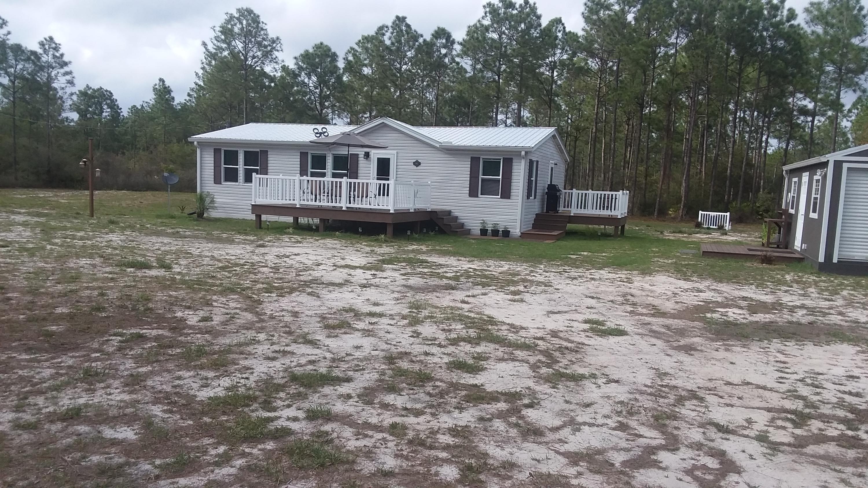 Double wide new floors , furnished ready to move in. This has a wonderful lockable storage shed plenty of yard. Has RV hookup with 30amp RV electrical hookup. Also has a tap to empty the RV directly into septic line to septic tank.  This property consist of five acres the back area is wooded  This is a quiet area with great neighbors. Owner will not finance or lease or rent. New metal roof installed 2019. John Deere riding mower conveys with property. New chest freezer conveys also,