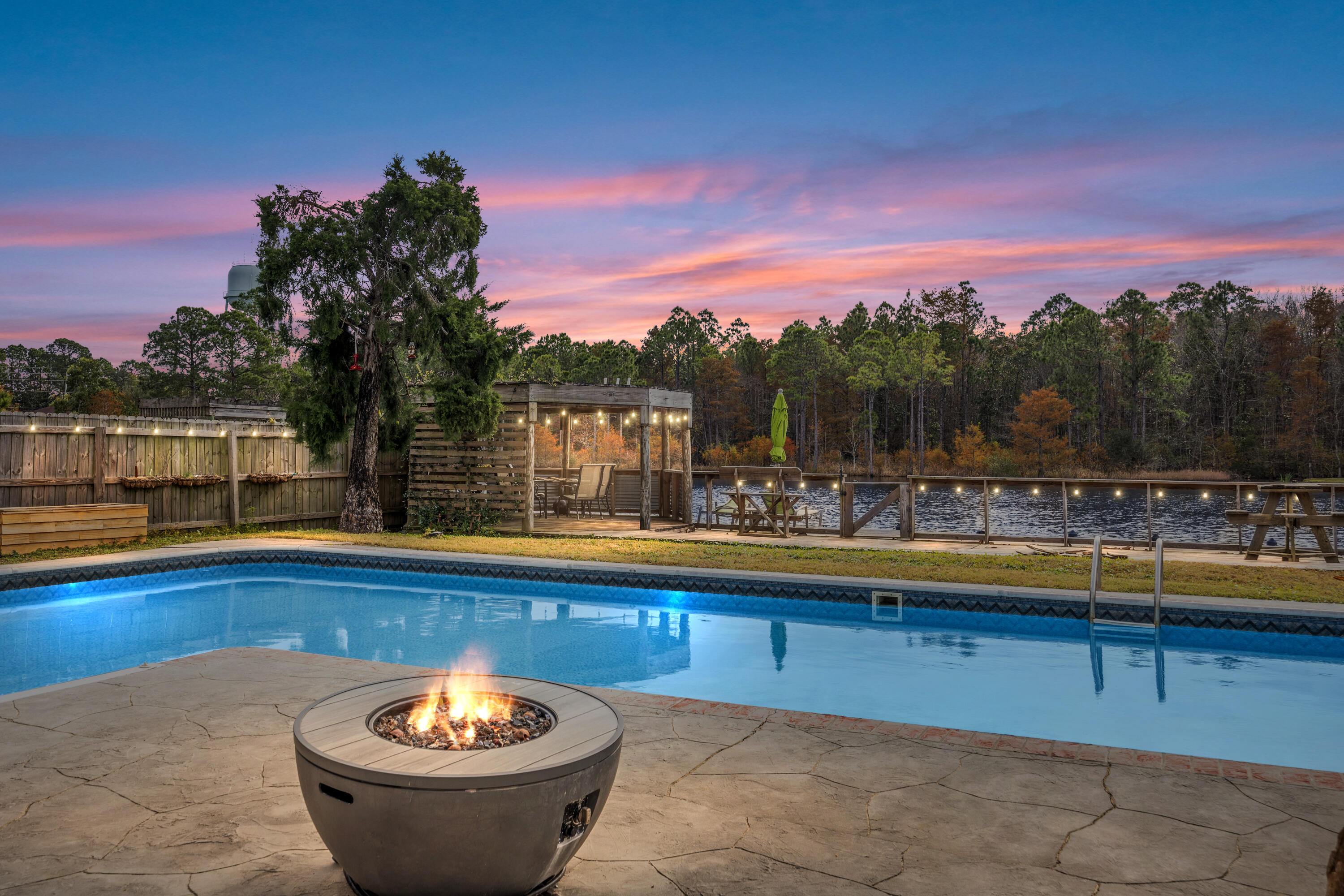 Back on the Market due to No Fault of Seller. Kick out clause in place. Welcome to 9589 Brentwood Blvd, a stunning home nestled in the highly sought-after East Navarre area. Located just 13 minutes from Hurlburt and 10 minutes from Navarres beautiful beaches . This spacious 4-bedroom, 2-bathroom residence offers over 2,200 sq. ft. of thoughtfully designed living space with a split floor plan, ensuring privacy and comfort for the whole family. As you enter, you'll be greeted by an inviting living room with high ceilings , updated flooring , and a beautiful fireplace creating a warm and open atmosphere. The kitchen features updated appliances , a pantry and freshly painted cabinets . Adjacent to the kitchen is a versatile office space, ideal for remote work or an additional bedroom . The generously sized master suite is a true retreat, complete with a spa-like en-suite recently updated bathroom featuring a soaking tub, walk-in tile shower, and dual vanities. The additional three bedrooms are equally spacious and offer plenty of closet space. Step outside and discover your own private oasis! A large inground heated and cooled saltwater pool featuring LED lights takes center stage, surrounded by an expansive deck that provides plenty of space for lounging and entertaining. The pool also been updated with  a top of the line pump and pool liner both only 4 years old .A charming gazebo offers a shaded area to relax, while the picturesque backyard overlooks a private lake  perfect for fishing, peaceful views, and enjoying nature's beauty. This home is located in a quiet, desirable neighborhood with easy access to local amenities. Don't miss your chance to own this extraordinary property that offers the ideal blend of luxury, comfort, and outdoor living. Schedule your private tour today! Roof and water heater both 2020 and HVAC 2017