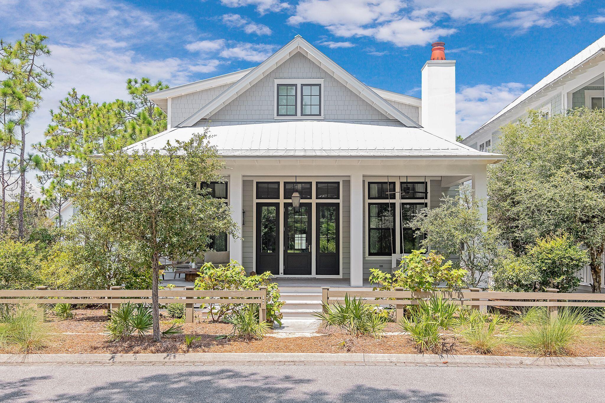 This phase 3 Watercolor beach house, designed by Dawn Thurber, built by Romair homes and beautifully decorated by Kirstie Carollo of Bella Beach offers 5 bedrooms, 5 ½ baths and is 3,224 square feet and radiates southern beach charm!  Upon arrival of the home you will take note of  the sizeable front porch finished with Satina Brazilian hardwood decking and an inviting swing bed that overlooks one of the many green spaces that Watercolor has to offer. As you enter the home you will immediately be welcomed by the soaring 12 foot raised ceiling with gorgeous white architectural beams, walls adorned with floor to ceiling white shiplap and an open floor plan that is light and bright and perfect for entertaining guests and enjoying family time! The living area is large yet cozy with a 48 inch fireplace finished with shiplap on the upper part and a custom milled stone surround that mimics shiplap as a focal point of the space and opens to the large dining area complete with a dry bar and 15 inch subzero ice maker. The kitchen has a large center island with elegant quartz countertop with an 18 inch countertop extension and finished cabinet panels along the sides and backside of the island. The kitchen offers a sizeable walk in pantry, a white Kohler farmhouse sink including a reverse osmosis filtered water system, a wood paneled 36 inch Sub Zero refrigerator, 48 inch wolf gas range with center griddle, 24 inch Subzero beverage refrigerator, Sharp microwave drawer and a wood paneled Asko dishwasher. The home has a generously sized laundry room with a utility sink, Carrara marble countertops and open shelving and access to storage under the stairs. A half bath is conveniently located in the hall. The home offers two bedrooms on the first floor, both with custom drapery,  large walk in closets and ensuite baths with custom tile and frameless glass shower doors. The home  has engineered wire brushed floors throughout the entire first floor with the exception of the bathrooms which all have custom tile and the bunk/game/media room (2nd floor) which has Shaw carpet. Journey on up to the second floor while enjoying the custom stair posts and balusters to find the master suite stunningly completed with a white shiplap ceiling, custom drapery, walk in closet, and the master bath with white subway tile in running bond pattern on the walls of the frameless walk in glass shower, quartz double vanity with a floating mirror and water closet, a kids dream of a bunk room with attached game/media room with Shaw carpet, custom drapery and an ensuite bath, finally an additional bedroom also with white shiplap ceiling, custom drapery, and an ensuite bath.  As if the home itself doesn't have it all, head on out to the back paver patio where the you will enjoy your own chlorine HEATED and COOLED pool with jets and blue quartz plaster.  If you don't feel like lounging in the pool then you can relax in some shade under the large cabana which offers a tv and a 42 inch outdoor fireplace also with a wood frame chimney, smooth stucco finish, quartz surround and hearth with reclaimed wood mantle. A perfect spot to hang with the kids to watch a movie or some football in the fall. The property has a large storage room (13.10 x 8) for all of your bikes and beach toys. Some other additional features this property offers are a tankless hot water system, security cameras, a wired and monitored fire and police alarm system, surround sound system for the televisions and sonos music sound system in the kitchen, dining room ceiling,  living room, front porch ceiling and back patio by both the pool and cabana. This property is located just one house off of the state park making it one of the quieter locations in Watercolor but yet still it is just a short walk to the Frog pool and also close to the bridge that crosses Western Lake into phase 1 of Watercolor leading to the beach. The home can also be conveniently accessed from the alley behind it and offers 4 parking spaces. WaterColor community includes residential homes and an award-winning beach side resort located on the beautiful Gulf of Mexico beaches and alongside serene Western Lake. The community is designed to have a small-town feel and is perfect for exploring on foot or by bike. Quaint streets and pathways connect homes to the community's parks, lush green spaces and shops. Resident have access to both tennis and pickle ball courts and a pro shop with tennis gear. Private lessons, group clinics and other activities are available throughout the year. The community also includes access to a boathouse with paddle boards, kayaks and fishing equipment; an outdoor amphitheater; a lakeside pool; and a bike barn. WaterColor is home to 9 community pools, including three at the Beach Club and three at Camp WaterColor (including a lazy river and waterslide). Camp Watercolor also offers a basketball court and a playground. Throughout Watercolor you will find 5 miles of hiking and biking trails, multiple park areas and several docks that are great to let the kids fish in.  Resort living at its finest!  Call to schedule a showing today!