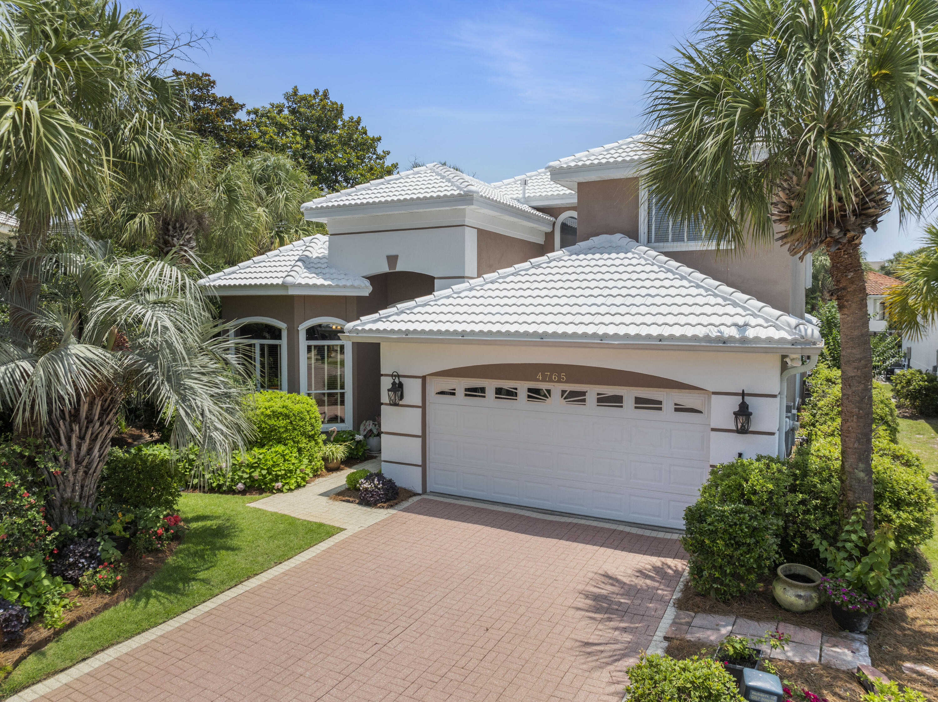 NEW 2025 ROOF!  Vacation or live full time at the beach in Destin in the exclusive gated community of Destiny East with outstanding amenities!  This beautiful custom built home sits on one of the largest lots in the community, almost a quarter acre. The lush landscaping around the house, designed by the Master Gardener Seller, is a must-see with stunning tropical plants, flowers, and mature trees including fruit trees.  First level presents a comfortable and inviting open living/dining and gourmet kitchen (featuring a gas cooktop) with a view of the pool and yard. This first level also has a library/den, large primary bedroom suite with french doors opening to the lounge area and pool, and a guest bedroom.  Second level has two additional guest bedrooms. Ceilings are 12', 10' and 9'. Custom Cherry Cabinets are found both in the kitchen and Library. Other features include Crown Molding and Trayed Ceilings, Central Vacuum, a new Generac Generator, a new roof installed May, 2025, new primary bath shower remodeled 2025, new fiberglass front door, new AC's, new gas water heater.  The house is wired for Security with land line, and has Hurricane Shutters. The Pool was resurfaced and Pool Enclosure replaced in 2021; In 2024 the pool deck was resurfaced and painted,  and pool pump, spa pump and control panel replaced.  The house is wired for Sound with speakers throughout including the Pool area. Seller has property inspection and stucco inspections and seller has made repairs. Amenities for the community are two pools, Clubhouse, Fitness Center, Theatre room, Playground, Tennis and Pickleball.  Easy beach access from this community. A rental income projection is attached.