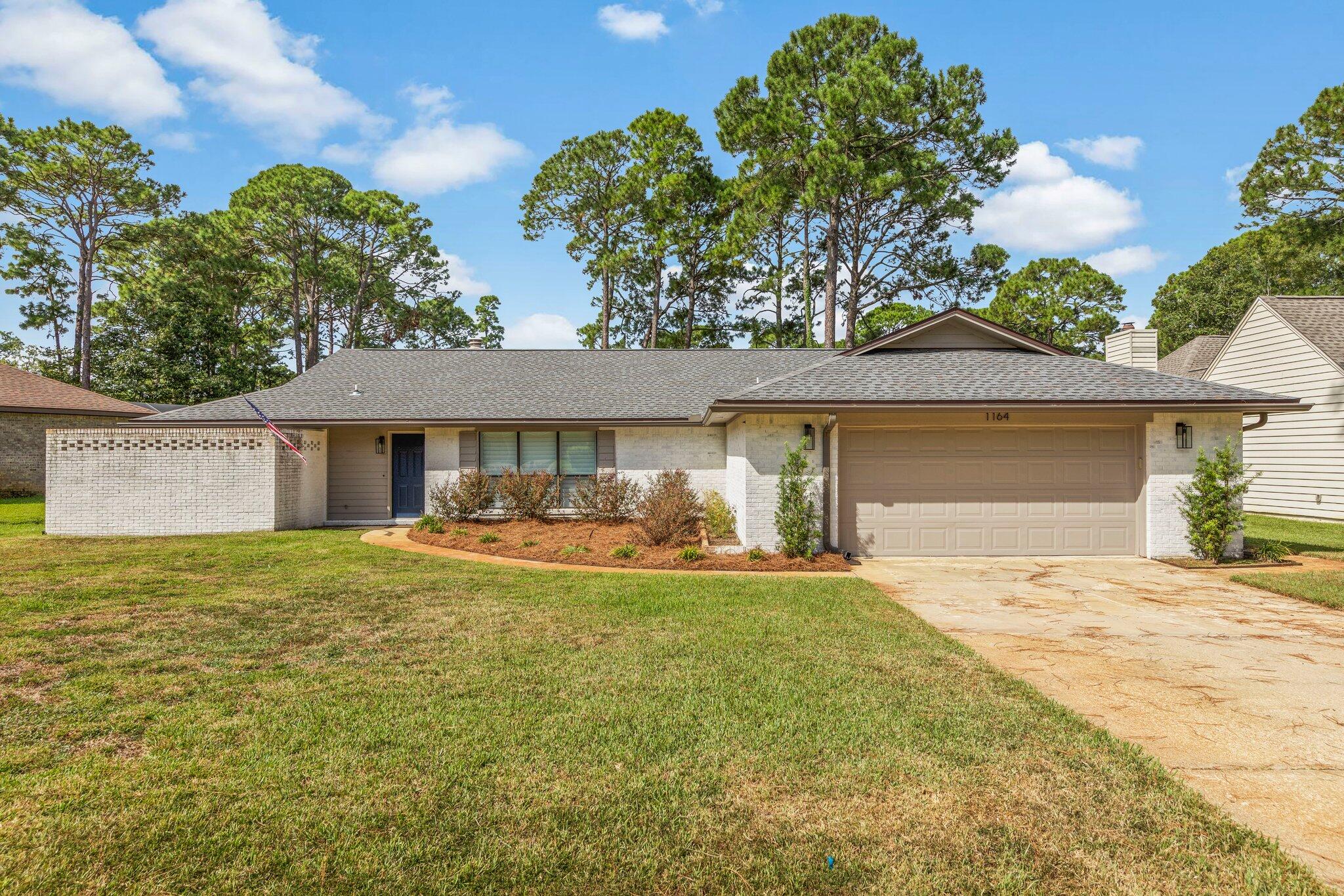 Fully updated modern home located in desirable Bluewater Bay. This 3bd/2ba home sits on a large lot and backs up to the 12th hole of the Bluewater golf course. Limewash brick brings curb appeal and compliments the large windows and modern fixtures that adorn the outside. An aesthetic open concept living space greets you as you enter this home with inviting LVP floors, whitewashed fireplace, LED lighting, and views of the golf course. A kitchen made for entertaining opens to the main space with a breakfast bar, clean bright counters, soft close cabinets and drawers, contemporary appliances, and a large apron sink. Bedrooms feature oversized windows that highlight the current and considerable updates of this beautiful home. The primary and secondary baths lend coastal luxury with shiplap accents, and complimentary paint colors. A large, enclosed Florida room allows for additional entertaining space, or quiet mornings sipping coffee. Call for your showing today!!