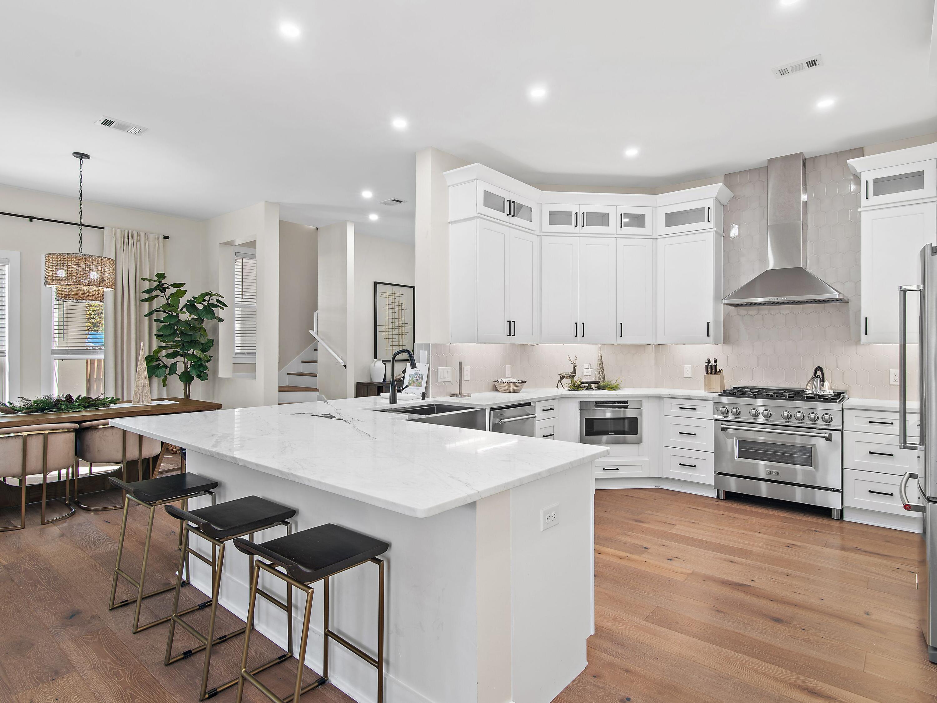 Set on one of the largest lots in the Eastern Lake area, this fully renovated coastal home offers an easy walk to the beach with two nearby public access points and a layout designed for relaxed gatherings and effortless entertaining. Mature trees frame the property, creating privacy and curb appeal, while a circular drive and additional parking pad provide ample space for guests, trailers, or golf cart.
Inside, the home has been thoughtfully updated from top to bottom. Hardwood floors run throughout the main living spaces, complemented by an open floor plan that flows seamlessly from the foyer to the backyard. The kitchen is a true centerpiece, featuring ceiling-height cabinetry, expansive L-shaped granite countertops with bar seating, stainless appliances, a gas range with  statement vent hood, built-in microwave, dedicated ice maker refrigerator, wine refrigerator, and tile backsplash extending to the ceiling. This space is equally suited for family meals and lively evenings with friends.
The residence includes three bedrooms and three bathrooms, along with a third-floor bunk room that comfortably sleeps 12 to 14 people. Bathrooms have been refreshed with new vanities, modern showers, a soaking tub in the primary suite, rainfall shower heads, white marble tile flooring, and curated designer finishes and wallpaper in some of the rooms.  A large wraparound balcony and a covered porch invite outdoor living, while the landscaped backyard offers a heated swimming pool and a fire pit, ideal for all the family and friends to enjoy.
Recent improvements include a new metal roof and HVAC system in 2023 and new hot water heater. The floor plan, oversized lot, and zoning provide flexibility for adding future living spaces for long-term value and versatility in this single family dwelling neighborhood.

Located near Eastern Lake Park with access to a public boat launch, this home enjoys proximity to the rare coastal dune lake system and the gulf beyond. With no required HOA there is an optional neighborhood association participation, this property delivers coastal living with freedom, space, and thoughtful design in a well-established beachside setting.